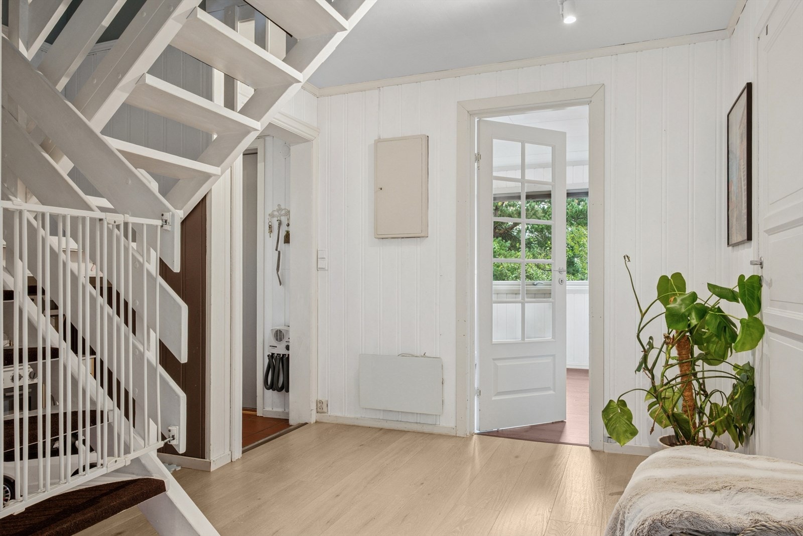 Den lyse og innbydende gangen fungerer som en sentral romfordeler i boligen, og skaper en naturlig flyt mellom husets ulike soner Galleribilde