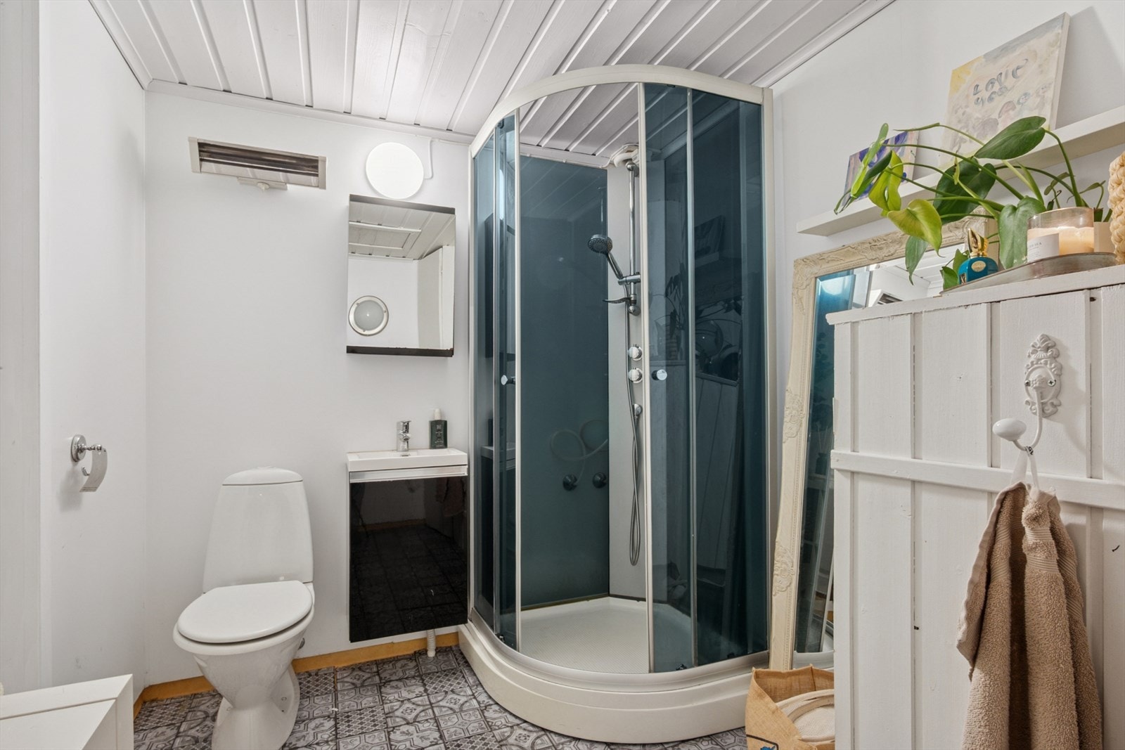 Badet har en funksjonell innredning med nedfelt servant, gulvmontert toalett og dusjkabinett. Alt du trenger for de daglige rutinene Galleribilde