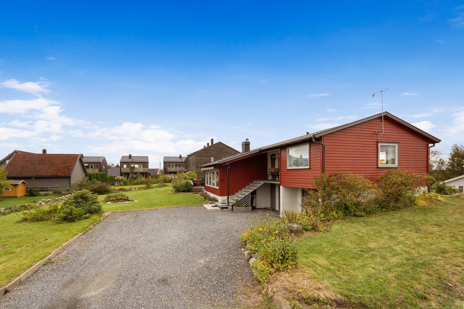 Gruset gårdsplass med innkjøring til garasje. Galleribilde