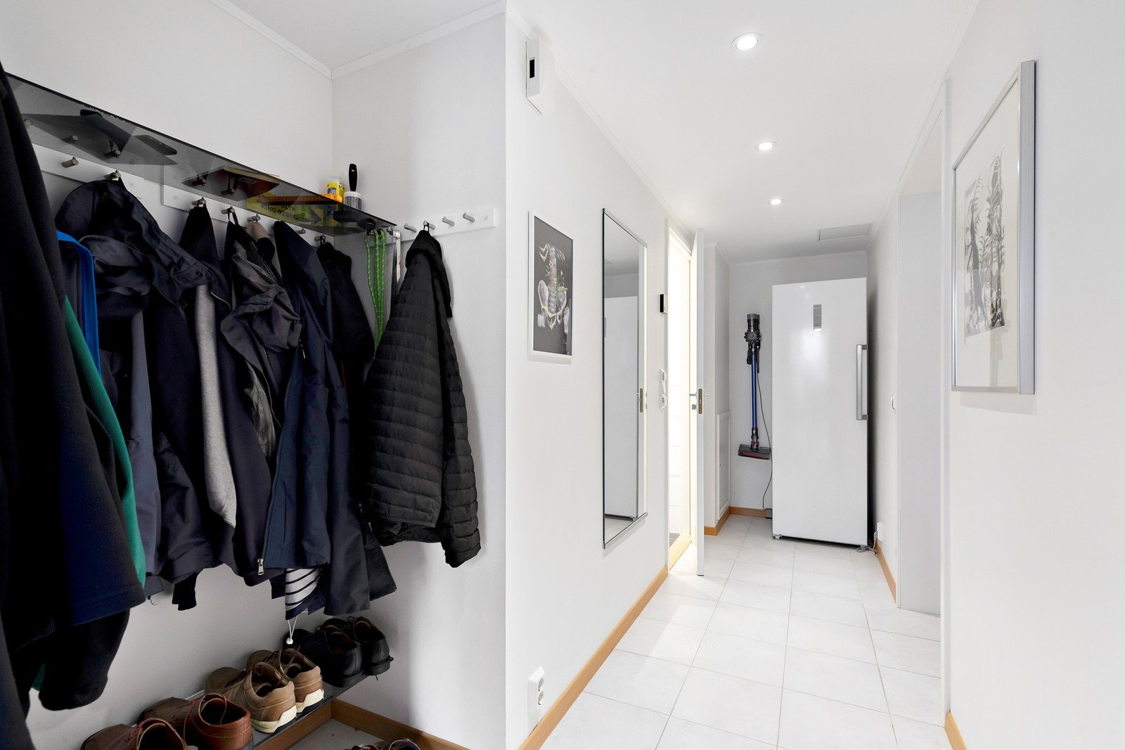 Lys og flislagt entré med varmekabler i gulv og god plass til klesoppheng Galleribilde