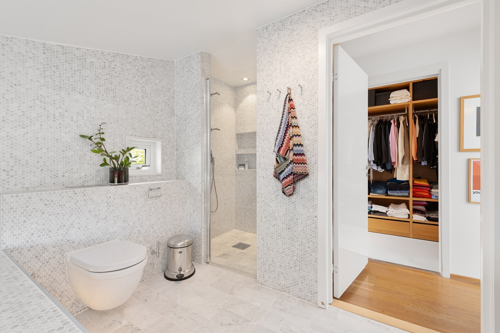 Dusjnisje med glassdør og vegghengt dusjarmatur. Vegghengt toalett. Galleribilde