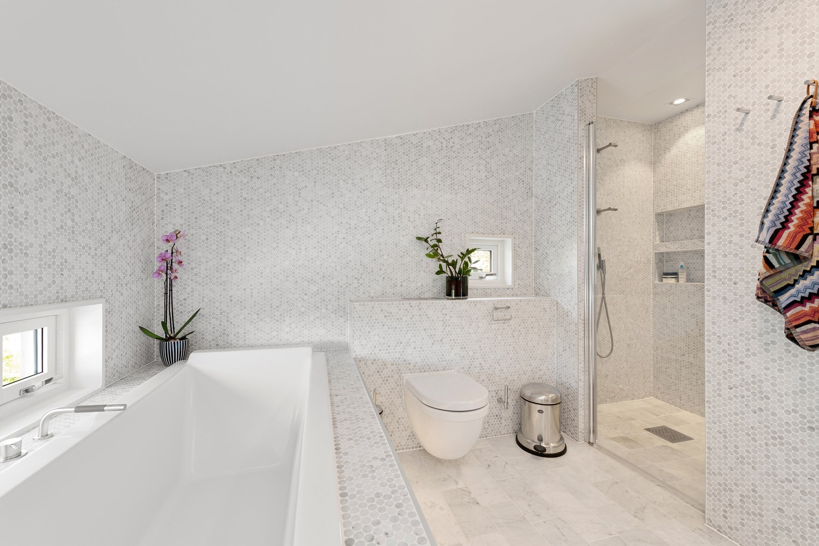 Bad i hovedetasjen er oppgradert i 2020. Flislagt gulv med gulvvarme, flislagte vegger og malt tak. Stor innredning i eik med ovenpåliggende dobbel servant med dobbelt armaturer. Speil med overlys og stikkontakt over servant Galleribilde