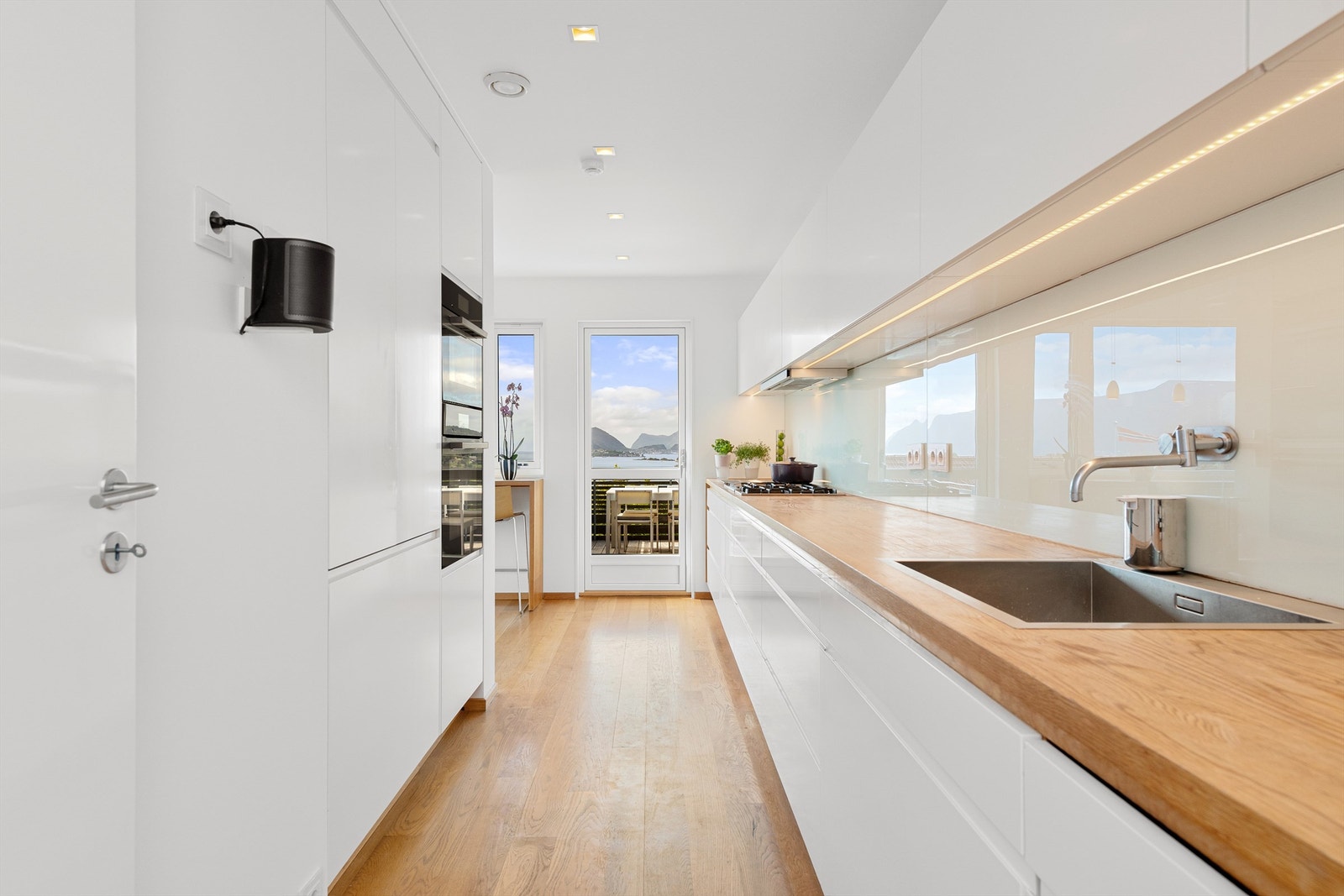 Kjøkkeninnredningen er fra Inoline/Lesjaskog Møbler med hvite glatte fronter fra 2022. Benkeplate av tre med nedfelt oppvaskkum og ett-greps kjøkkenarmatur Galleribilde