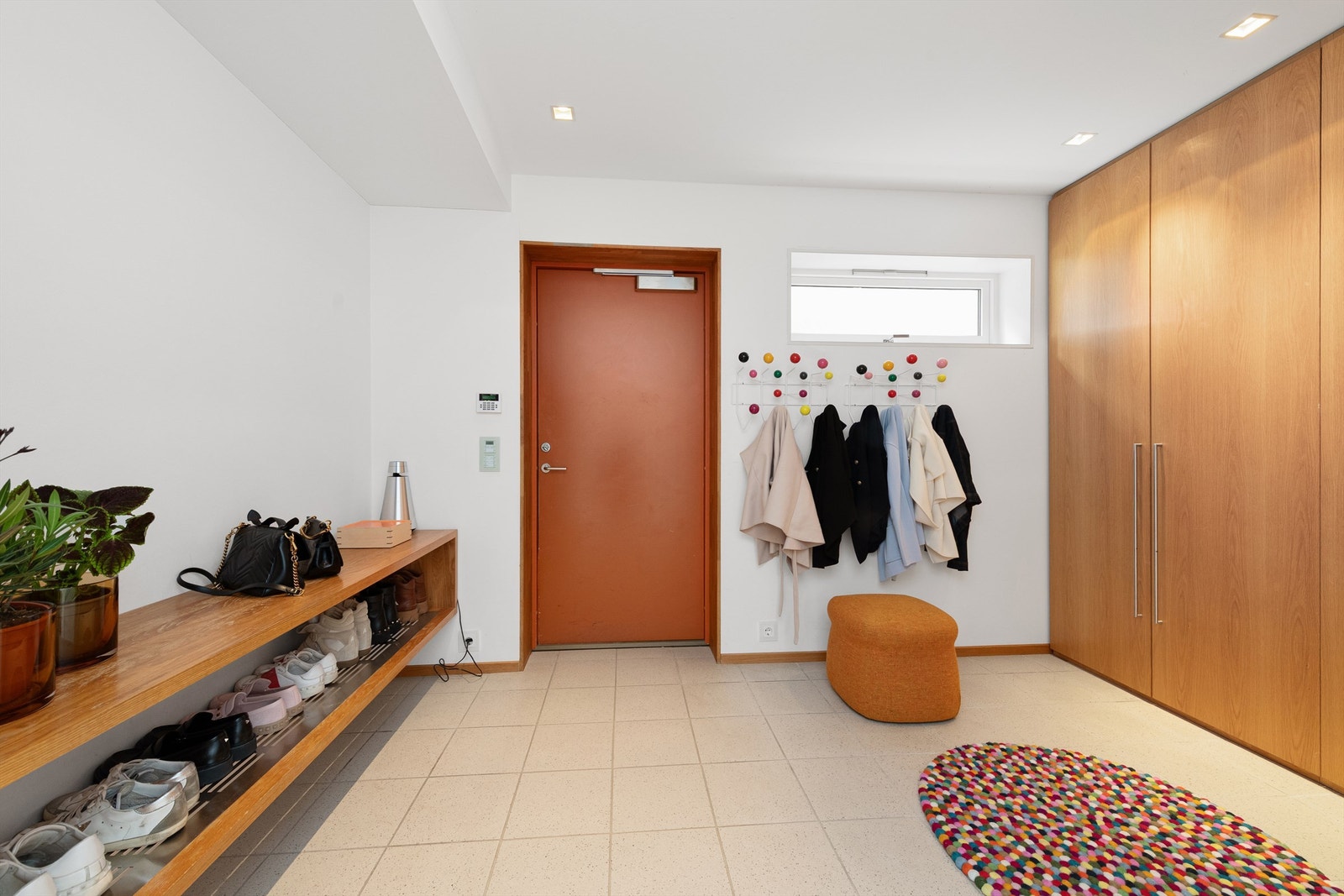 Entre med flislagt gulv, malte vegger og tak med innfelte spotter. Fastmontert benk med skooppbevaring samt stor garderobeinnredning med gode oppbevaringsmuligheter. Galleribilde