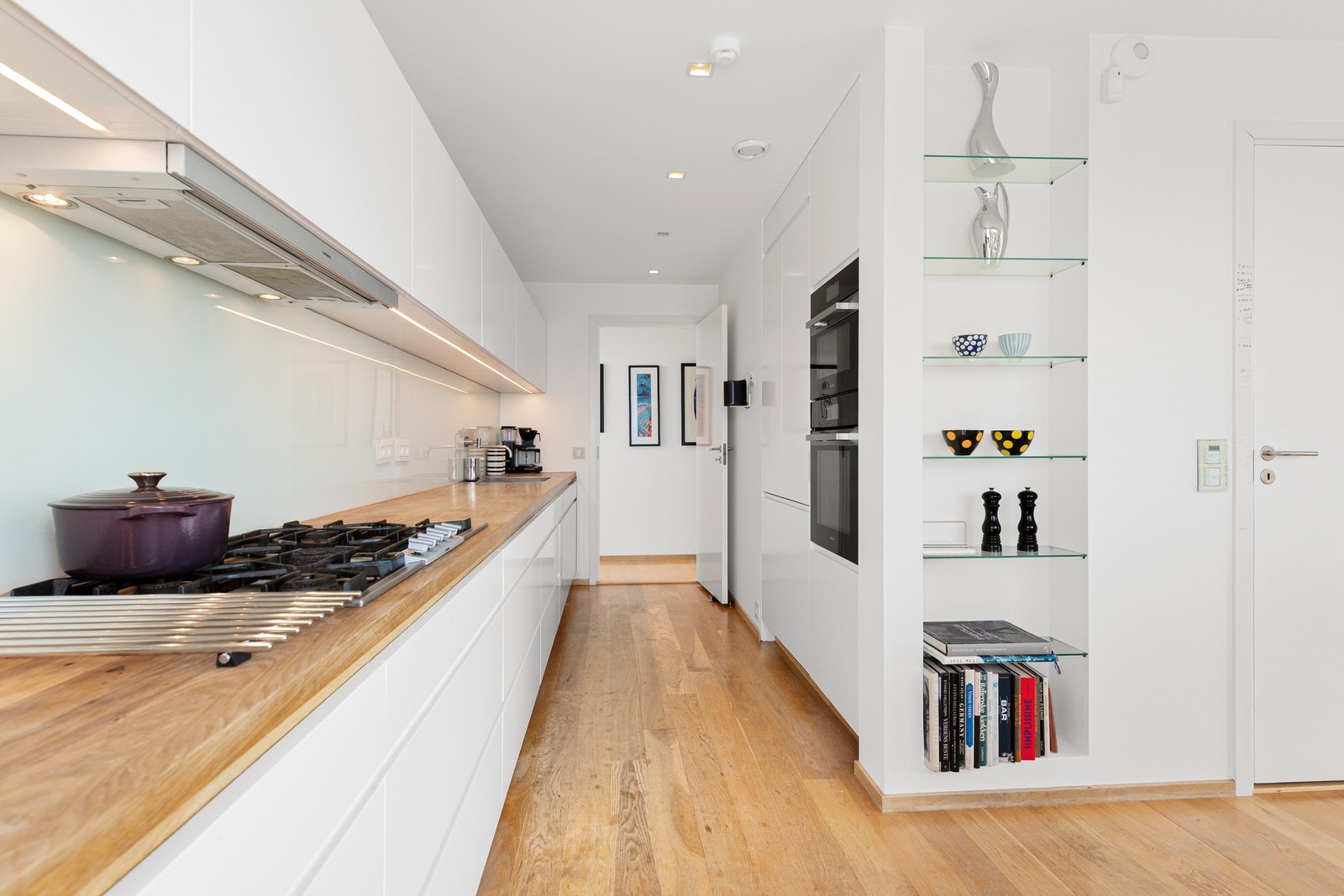 Det er benkeplate av tre med nedfelt oppvaskkum med ett-greps kjøkkenarmatur. Benkeskapsbelysning og stikkontakter over kjøkkenbenk. Galleribilde