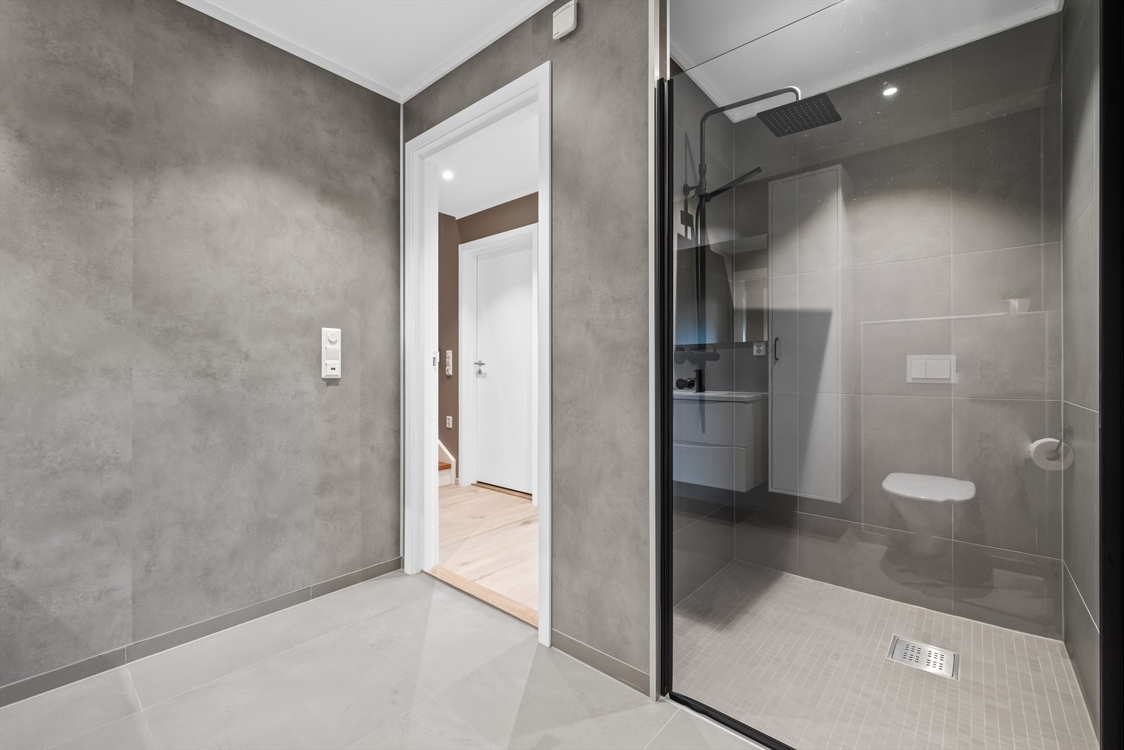 Badet er utstyrt med dusjnisje, mekanisk avtrekk, servant, servantskap og veggmontert wc. Galleribilde