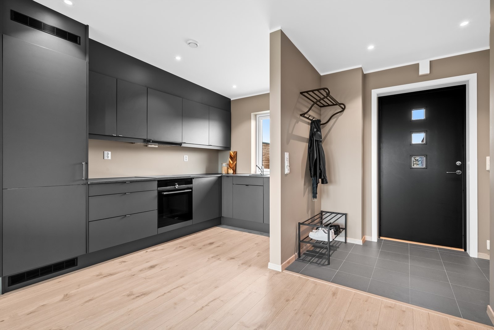 Kjøkkenet er stilrent og har godt med skap- og benkeplass. De romslige arbeidsflatene gjør det enkelt å tilberede måltider. Galleribilde