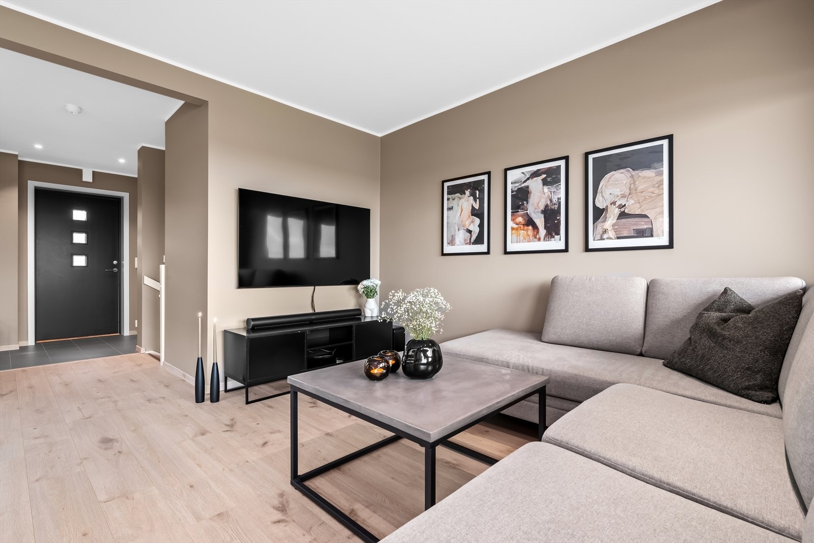 I stuen er det lagt til rette for et hyggelig sofahjørne. Veggene er malt i duse, moderne farger som gir boligen et innbydende preg. Galleribilde