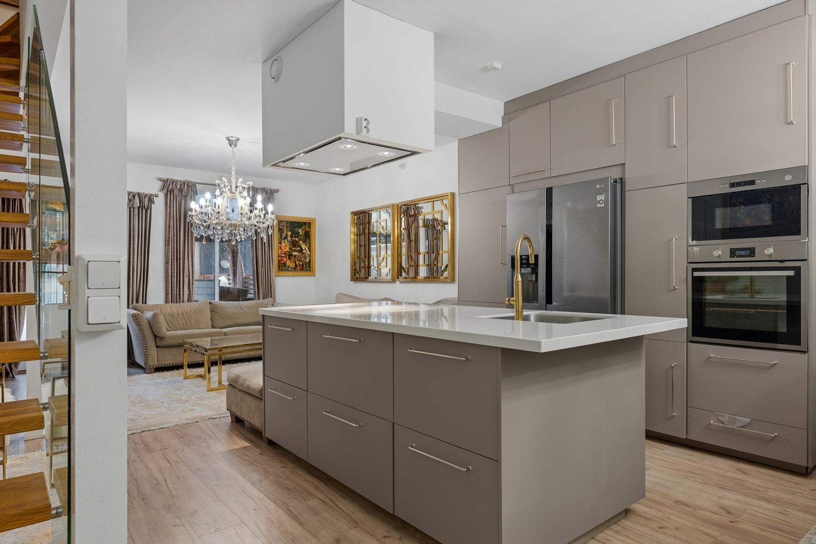 Kjøkkenet var nytt i 2018 og er tidløst innredet med gråbeige fronter og hvit benkeplate. Gulldetaljer er gjennomgående og gir kjøkkenet et eksklusivt preg. Galleribilde