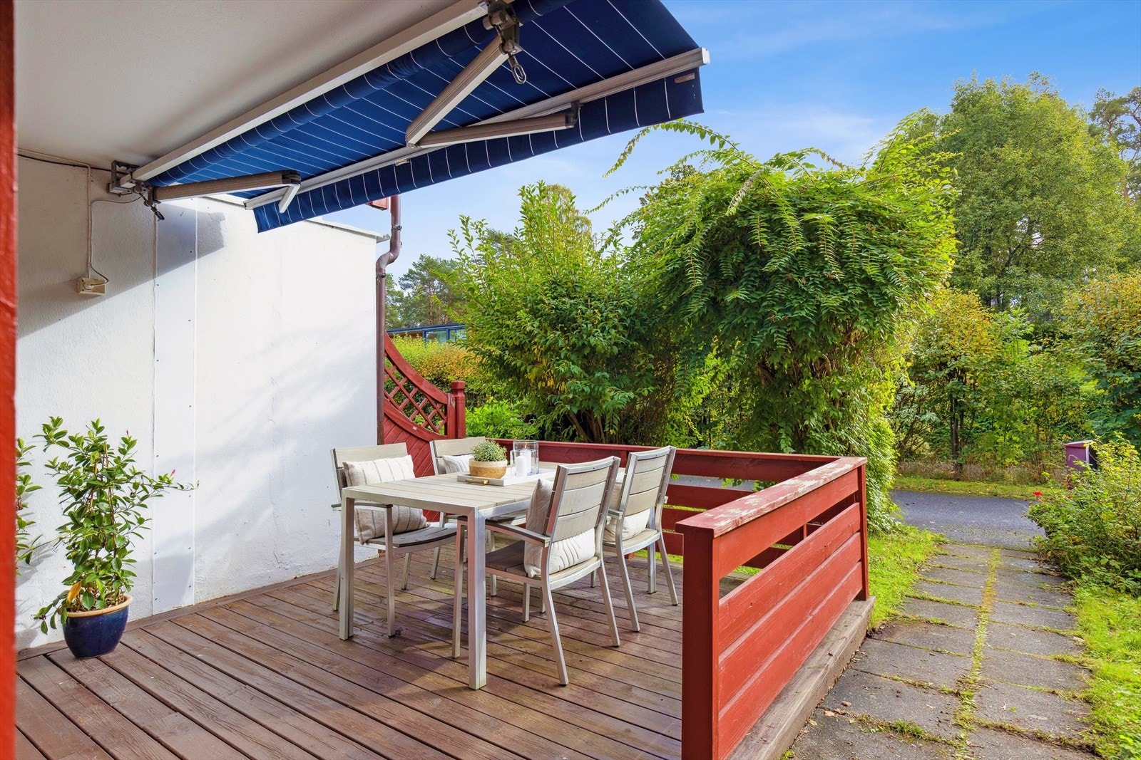 16 m² terrasse i forlengelse av stuen - helt uten gjenboere. Solrik og skjermet med markise - perfekt for rolige stunder i grønne omgivelser. Galleribilde