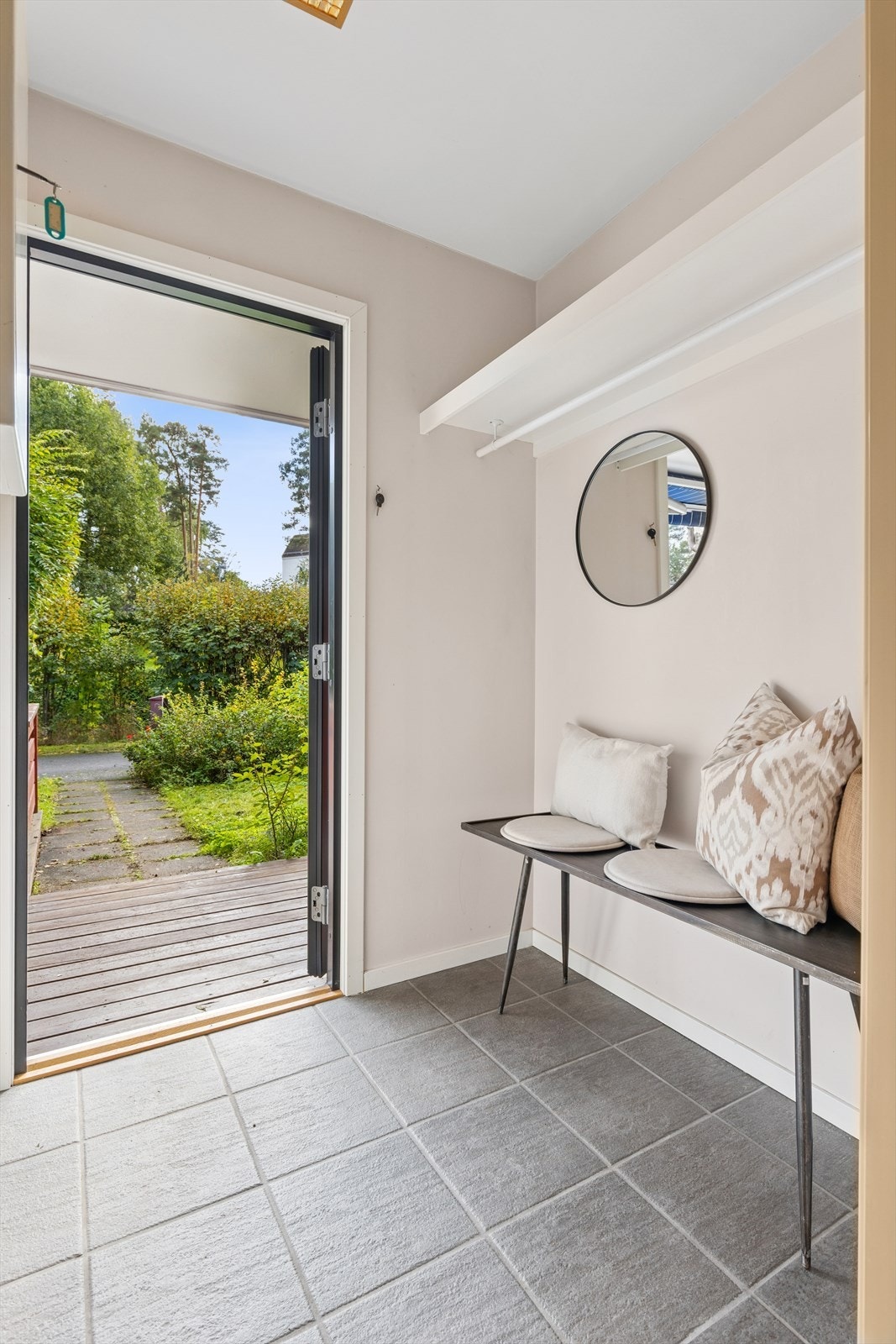 Praktisk vindfang med slitesterkt, flislagt gulv - en funksjonell velkomst til hjemmet. Galleribilde