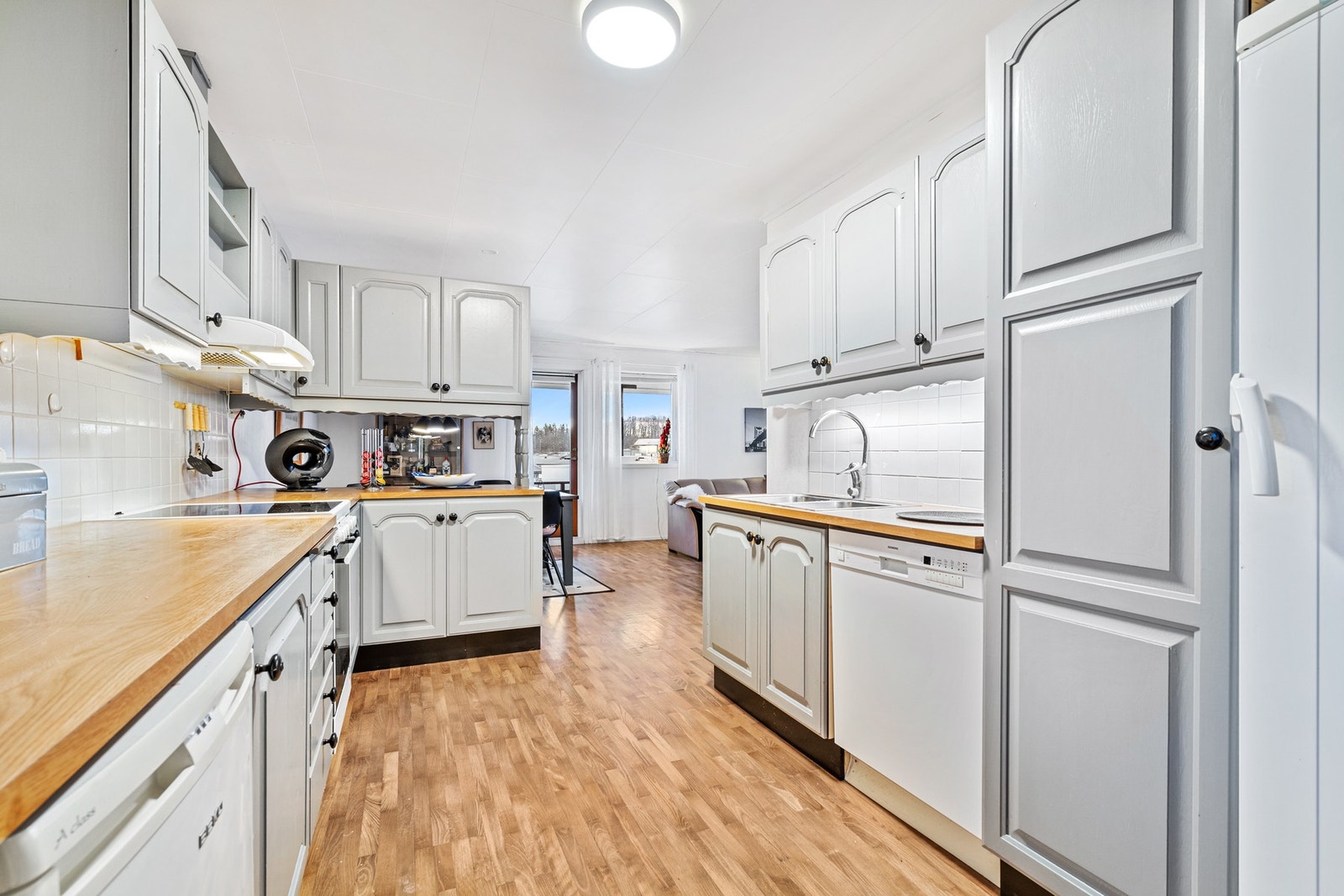 Kjøkkeninnredning har malte profilerte fronter og laminat benkeplate Galleribilde