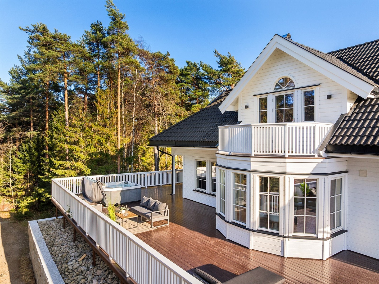 Hvitmalt stakittgjerde rammer pent inn uterommet på så vel terrassen som altanen og balkongen. Galleribilde