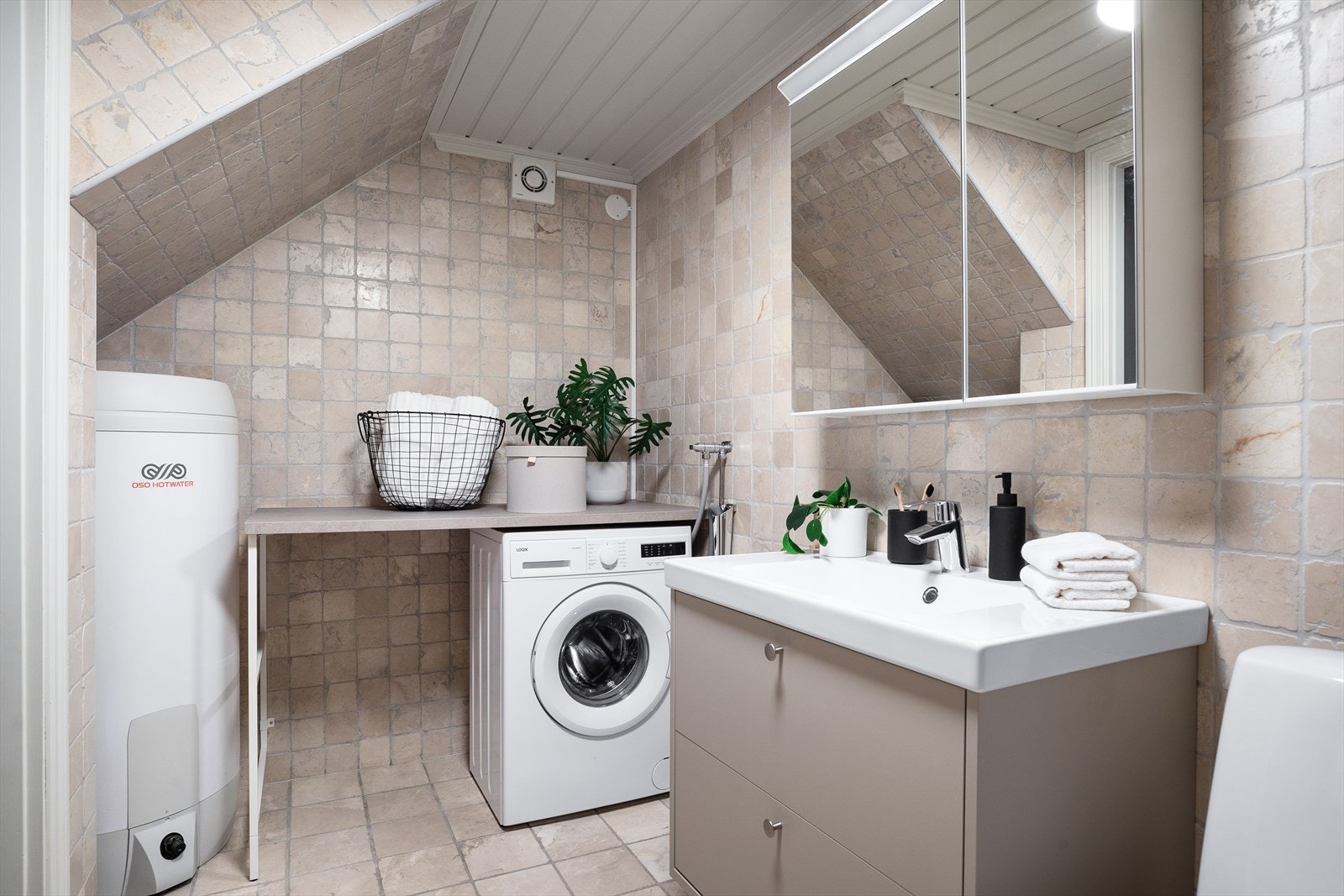 Innerste del av rommen er innredet med benkeplate i laminat, opplegg for vaskemaskin og tørketrommel, samt varmtvannsbereder, vannmåler og hovedstoppekran. Galleribilde