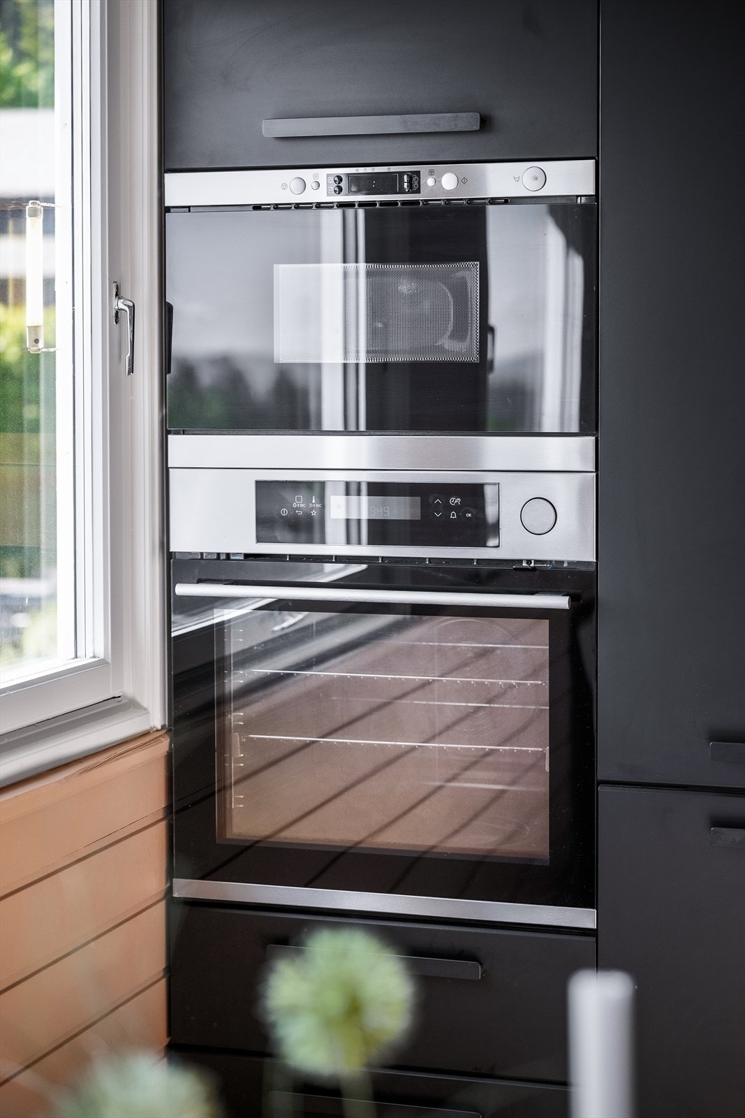 Integrerte hvitevarer med induksjonstopp, stekeovn og mikrobølgeovn i arbeidshøyde, oppvaskmaskin, kjøleskap og fryser. Galleribilde