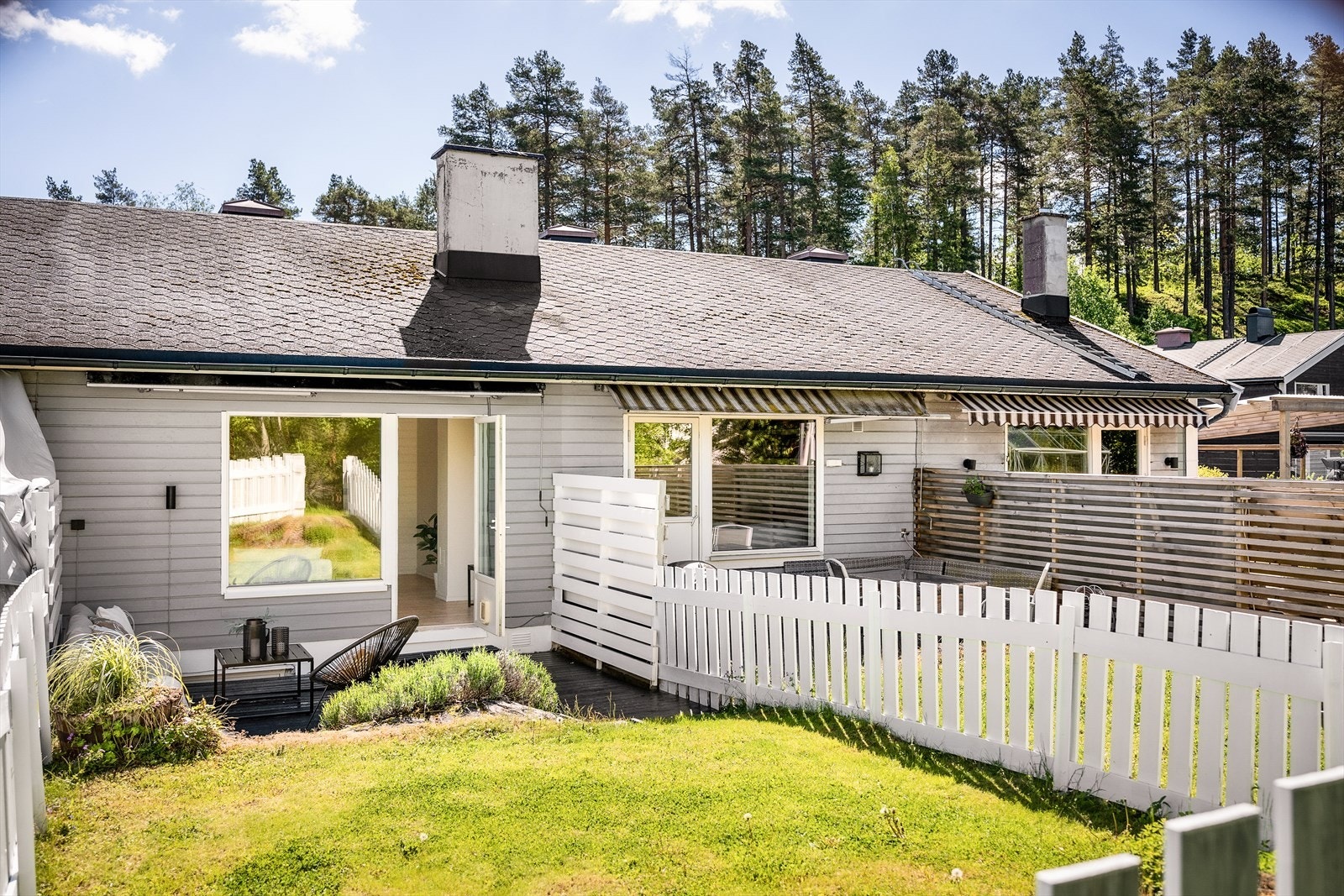 Uteplassen omkranses av hvitmalt gjerde som gir en fin ramme rundt uteområdet. Galleribilde