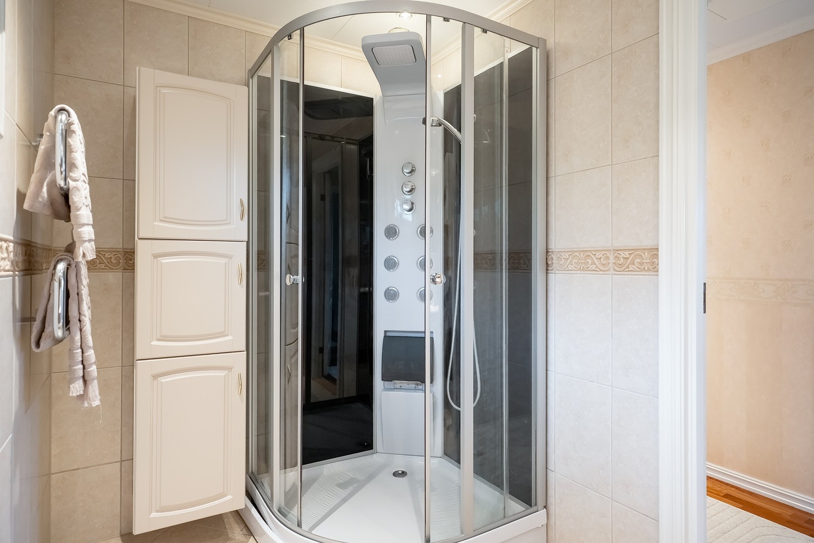 Hovedbadet har innredning med servant, høyskap og dusj.
