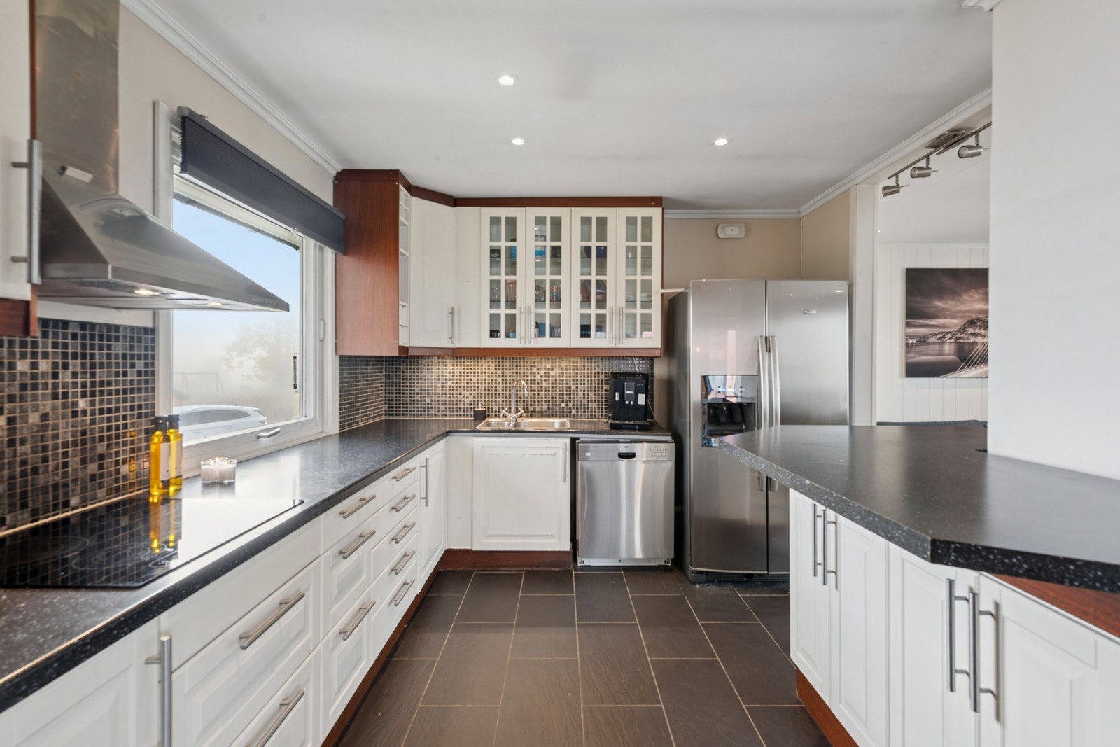 Boligen har et romslig og moderne kjøkken med åpen løsning mot stue og spiseplass. Galleribilde