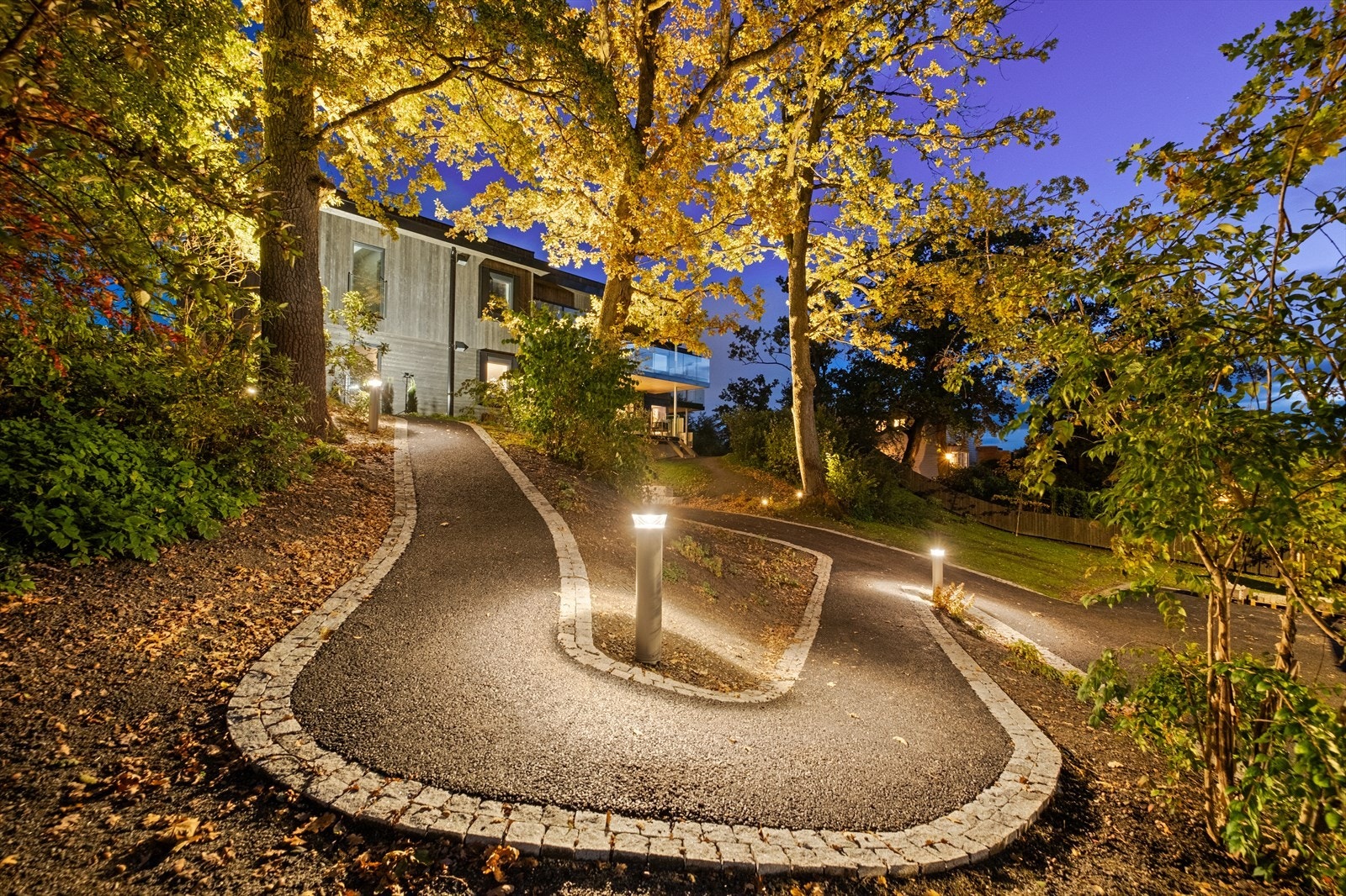 Gangsti opp til inngangsdør med varme i asfalten og lyssatt hele veien Galleribilde