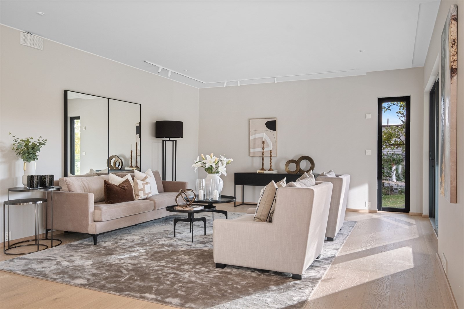 Stuen har tidløs eleganse og vakre detaljer. Gjennom de store vinduene flommer naturlig lys inn i rommet. I himling er det smarte detaljer for gardinoppheng. Bildet er fra leiligheten i 1. etasje. Galleribilde