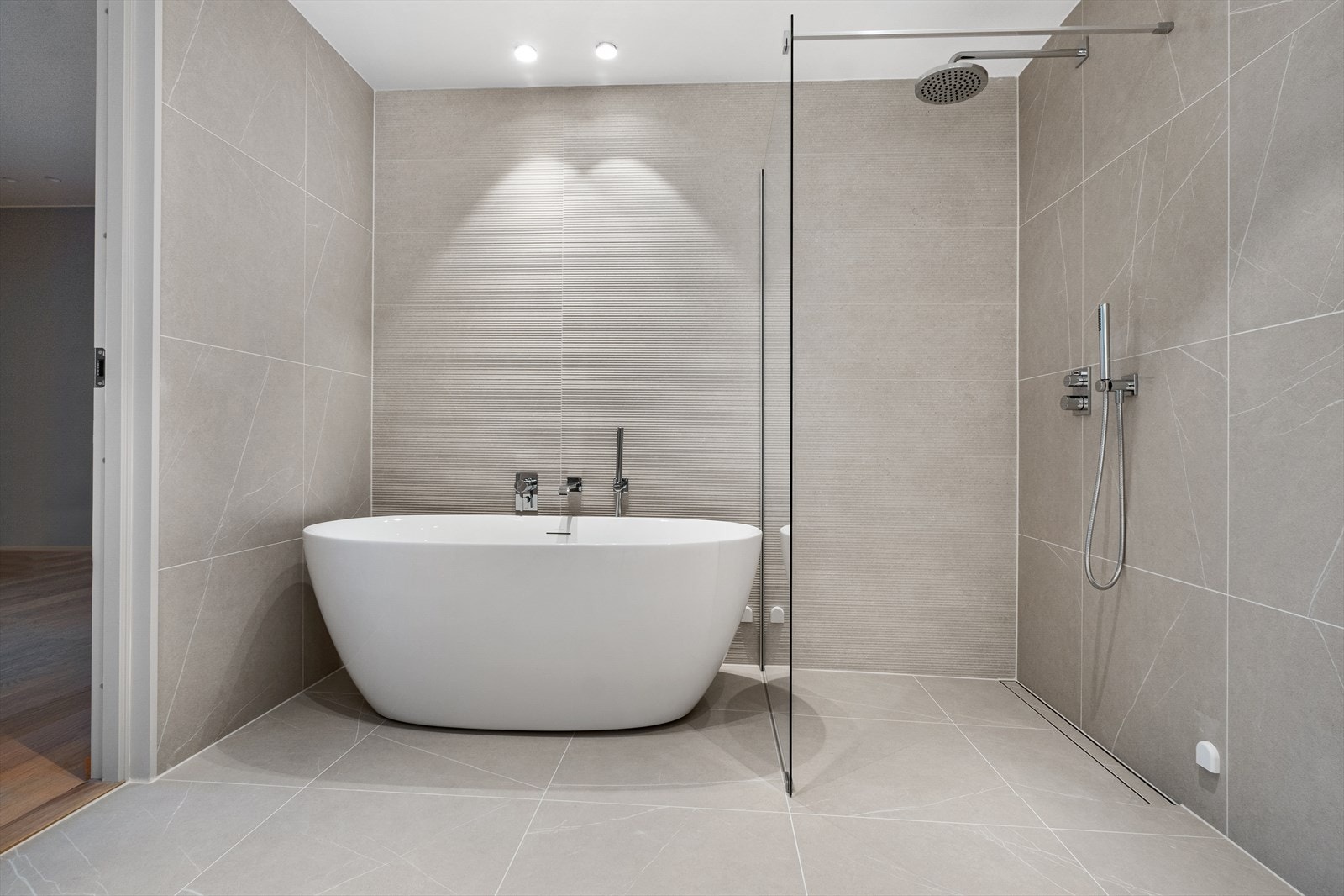 Badet har en lekkert kontrastflis bak badekar og dusj. En elegant utførelse som gjør det lille ekstra Galleribilde