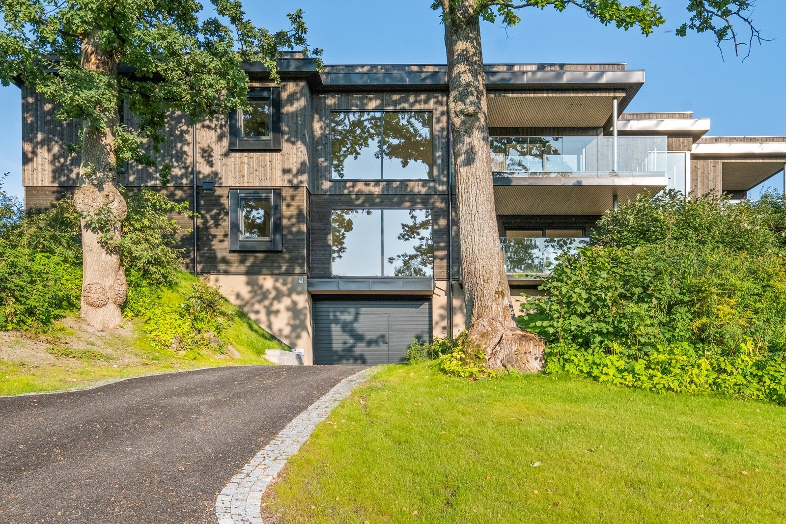 Velkommen til Risbakken 20. Fasade med stilige detaljer. Innkjøring til garasjen med kantstein og drenerende asfalt Galleribilde