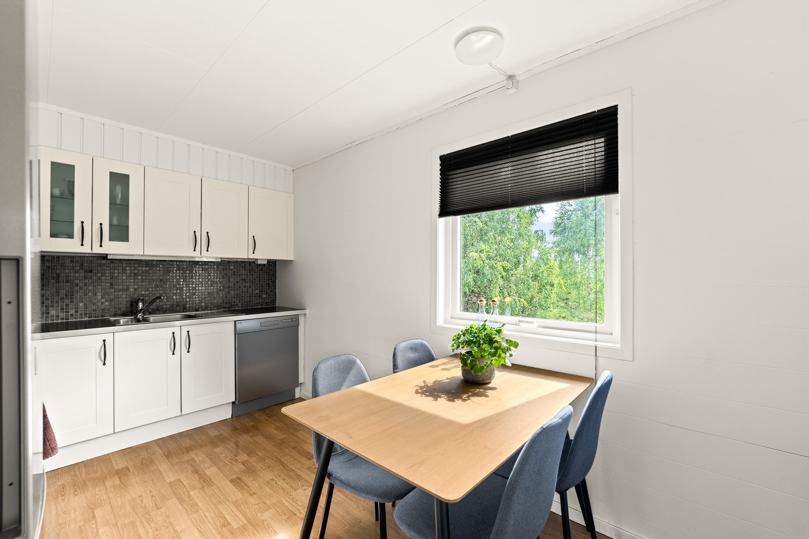 Lys kjøkkeninnredning med plass til en spisegruppe. Galleribilde