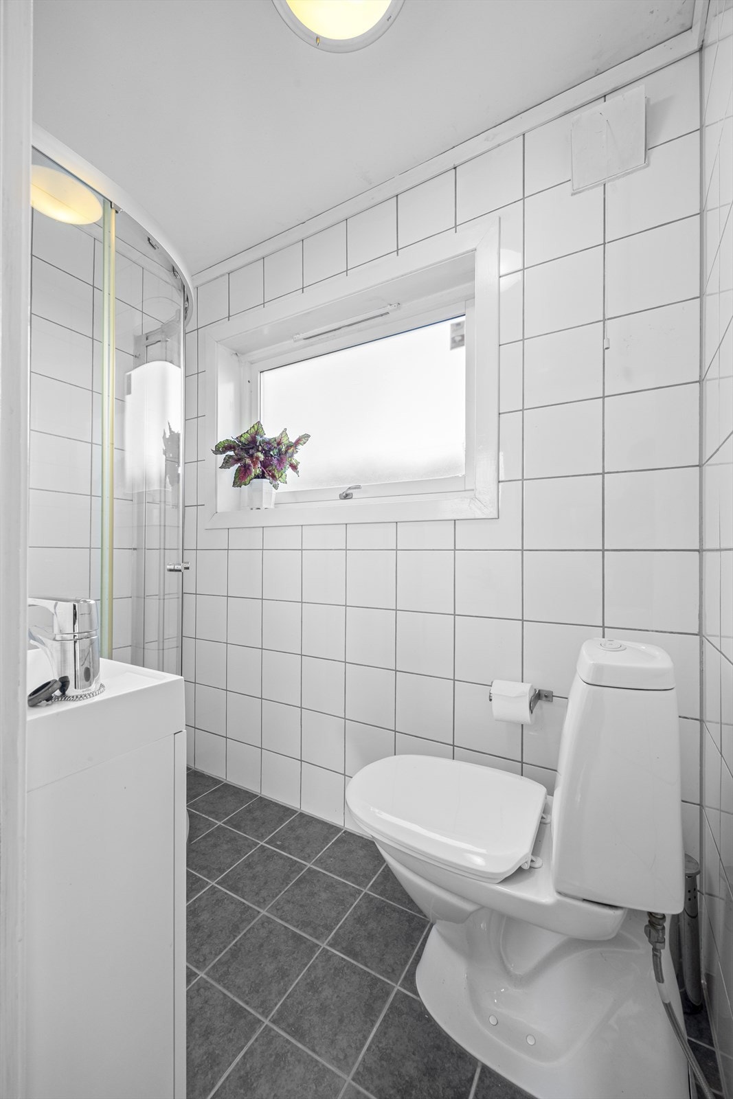 Bad med dusjhjørne, servant og toalett. Galleribilde