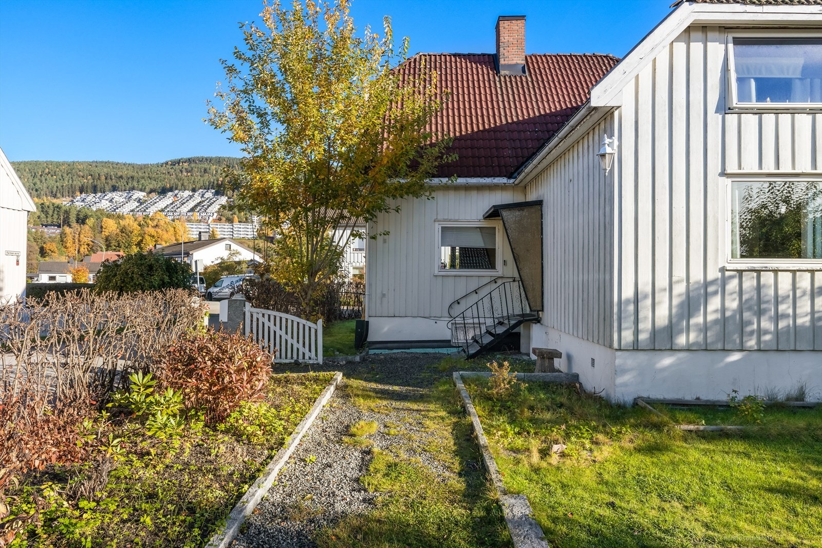 Opparbeidet hage med gruslagt gangvei, staudebed og gressplen. Galleribilde