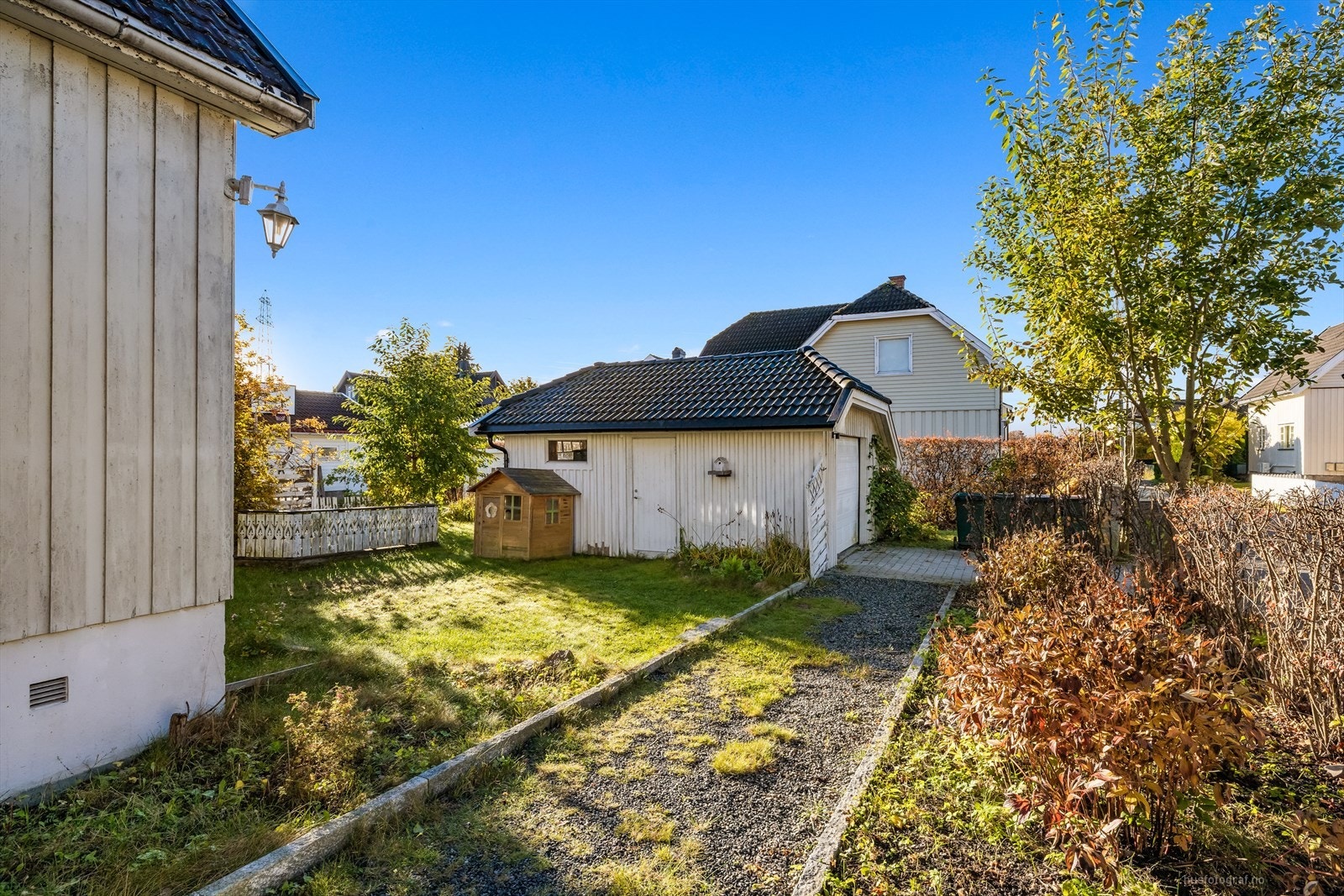 Gruslagt gangvei bort til romslig garasje. Galleribilde