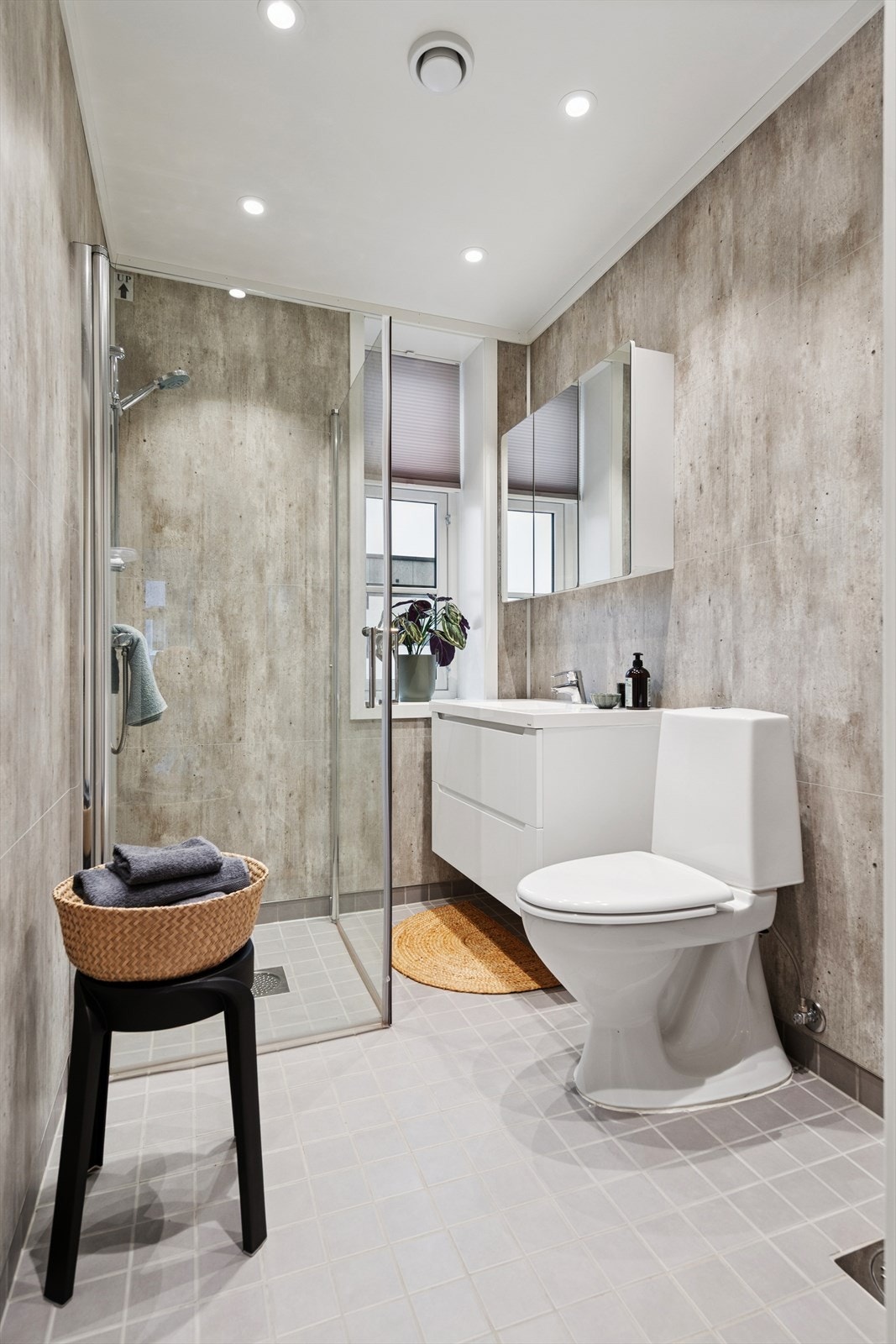 Moderne bad med dusjhjørne, vegghengt toalett og praktisk opplegg for vaskemaskin. Galleribilde