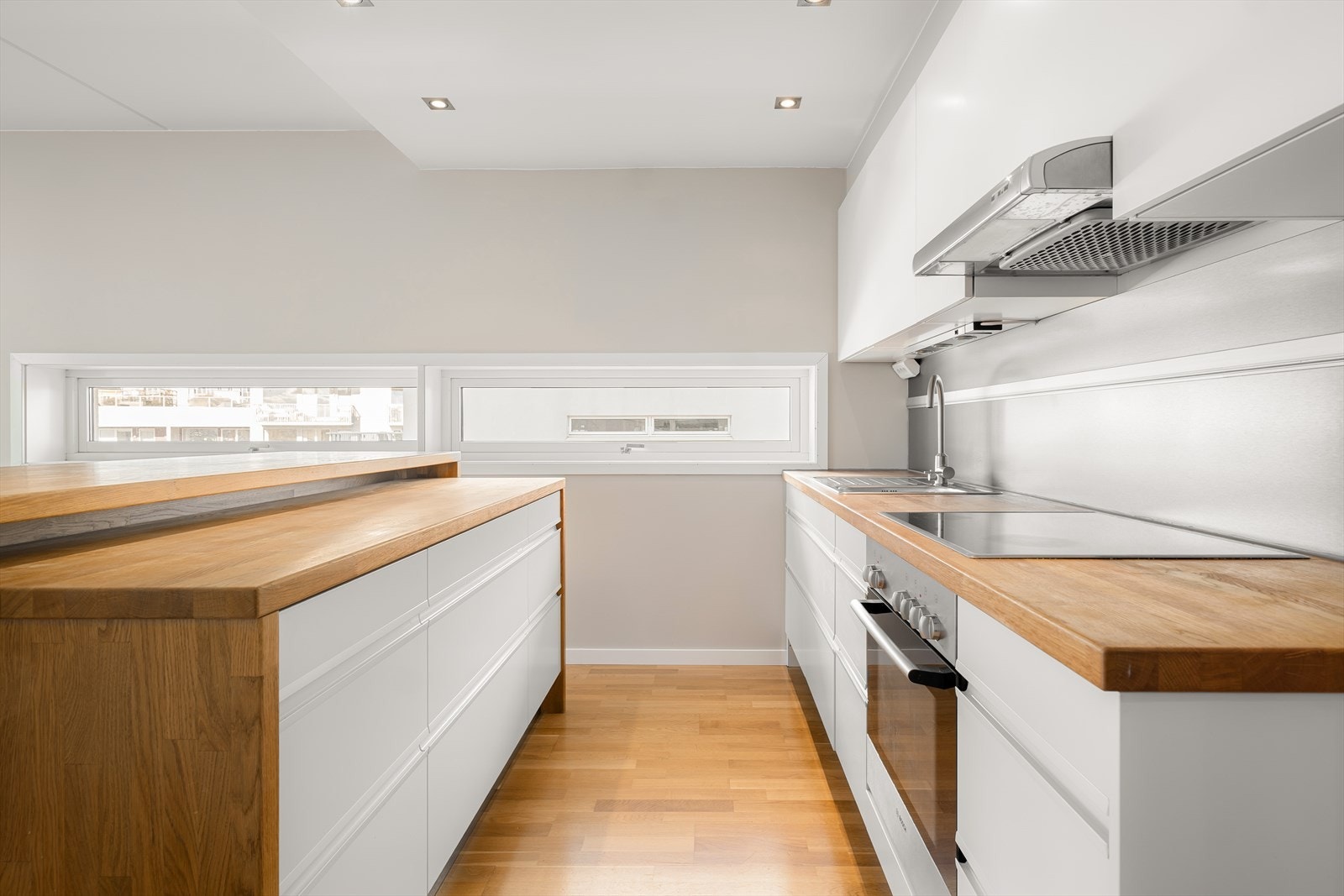 Kjøkkenet er lyst og moderne, med integrerte hvitevarer og en praktisk kjøkkenøy som gir ekstra arbeidsplass. Galleribilde