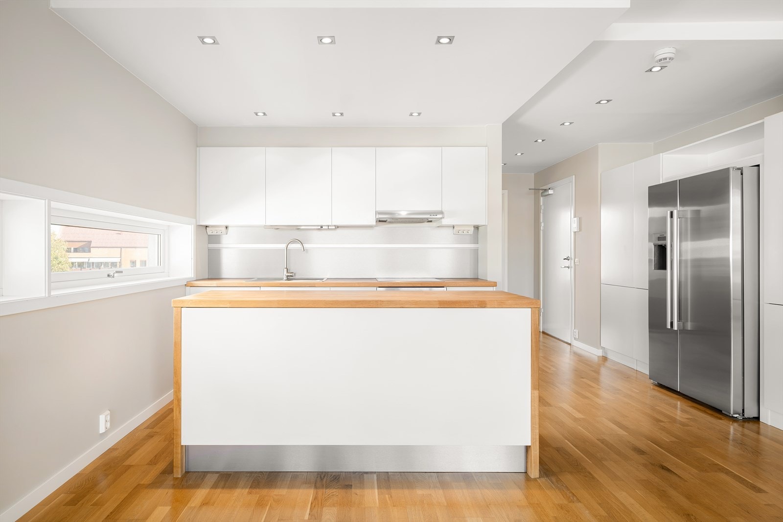 Kjøkkenet er praktisk utstyrt med kjøleskap og fryser med vann- og isbitdispenser, pent plassert i egen nisje. Galleribilde