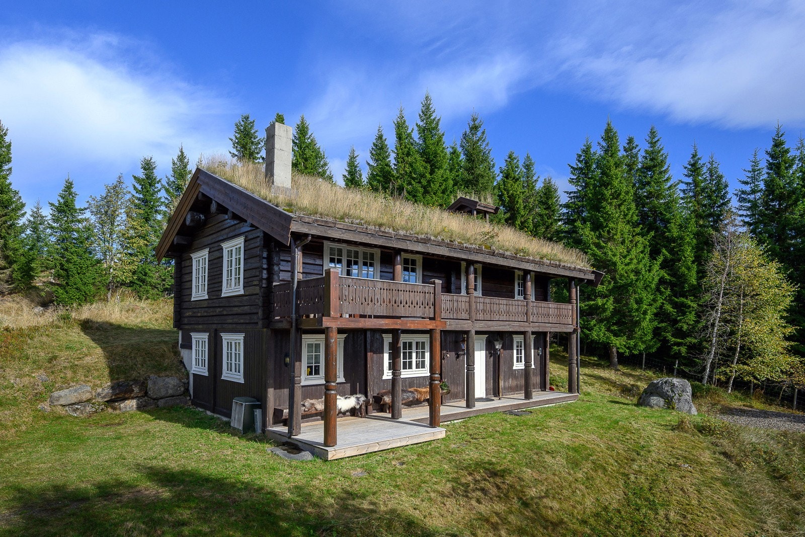 Tomten er opparbeidet med plen og treterrasse. Forstøtningsmurer av naturstein. Galleribilde