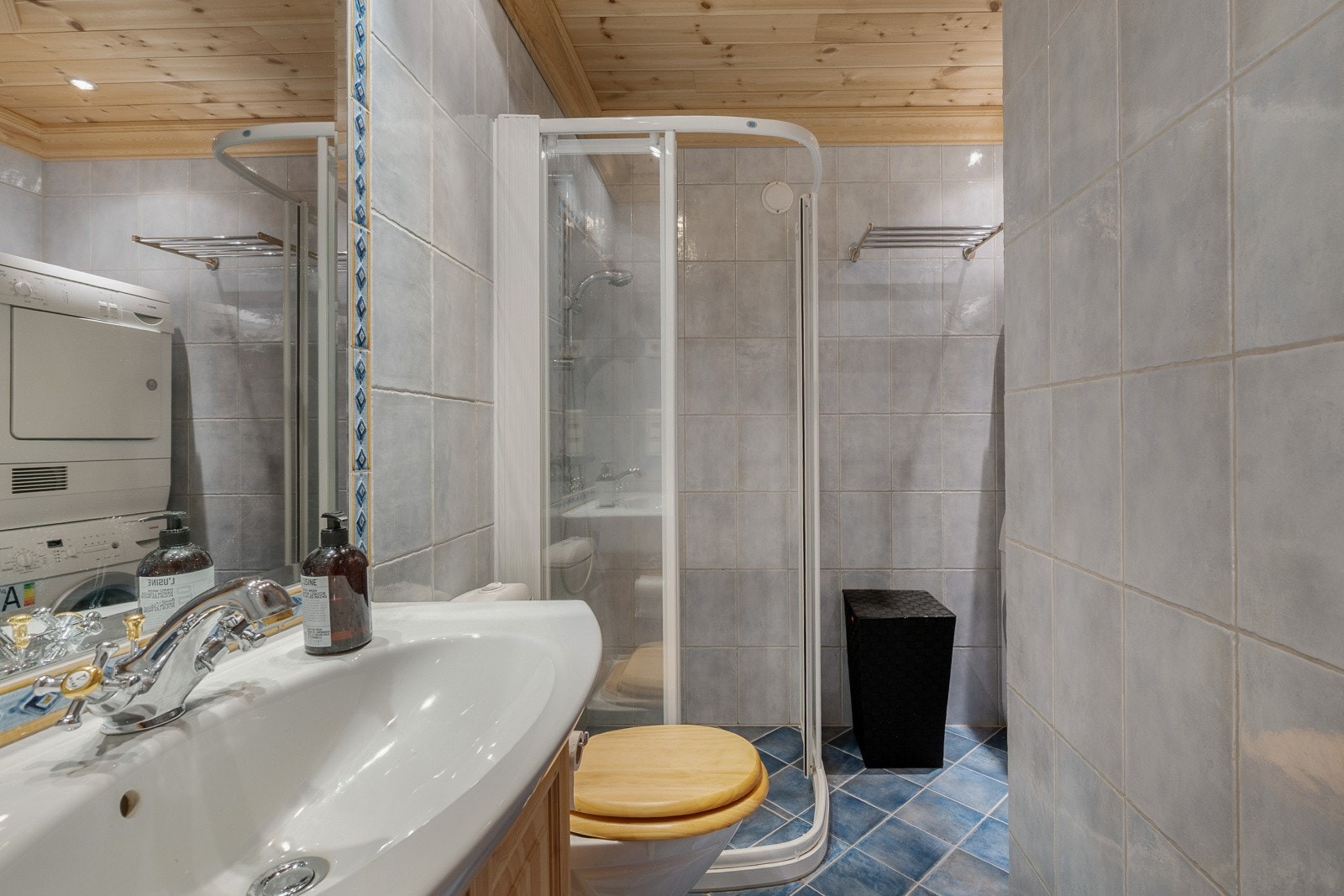 Kombinert bad/vaskerom i underetasjen. Innredning med nedfelt servant, gulvmontert toalett, dusjvegger/hjørne og opplegg for vaskemaskin. Galleribilde