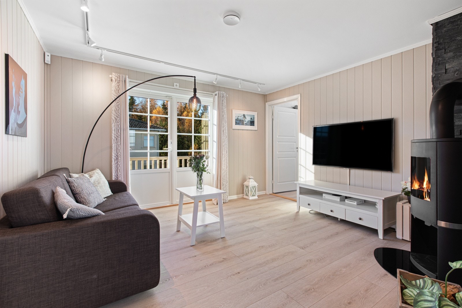 Stuen i andre etasje har utgang til balkong, flott peisovn og god plass til sofagruppe og Tv-benk Galleribilde