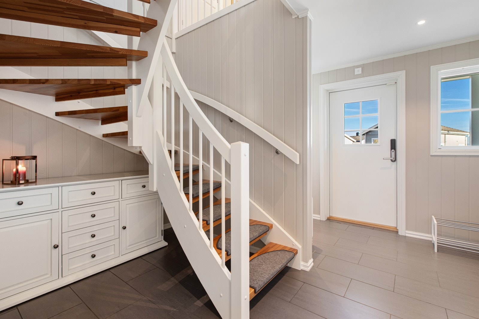 Entreèn har lysmalt panel på veggene, downlights i himlingen og grå, store fliser på
gulv med gulvvarme. Galleribilde