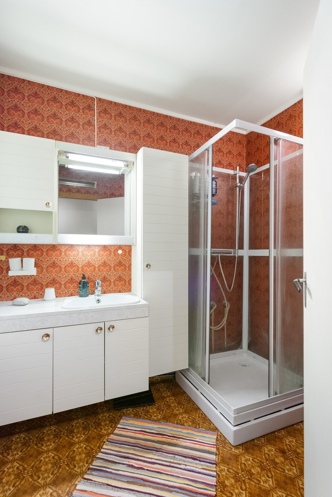 Praktisk baderom med dusjkabinett, servant og oppbevaringsmuligheter Galleribilde