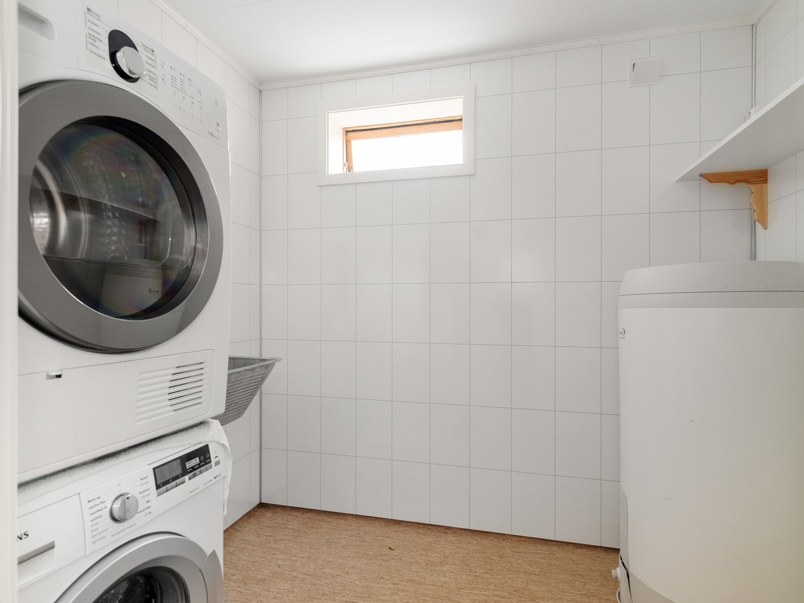 Lyst og funksjonelt vaskerom med opplegg for vaskemaskin og tørketrommel Galleribilde