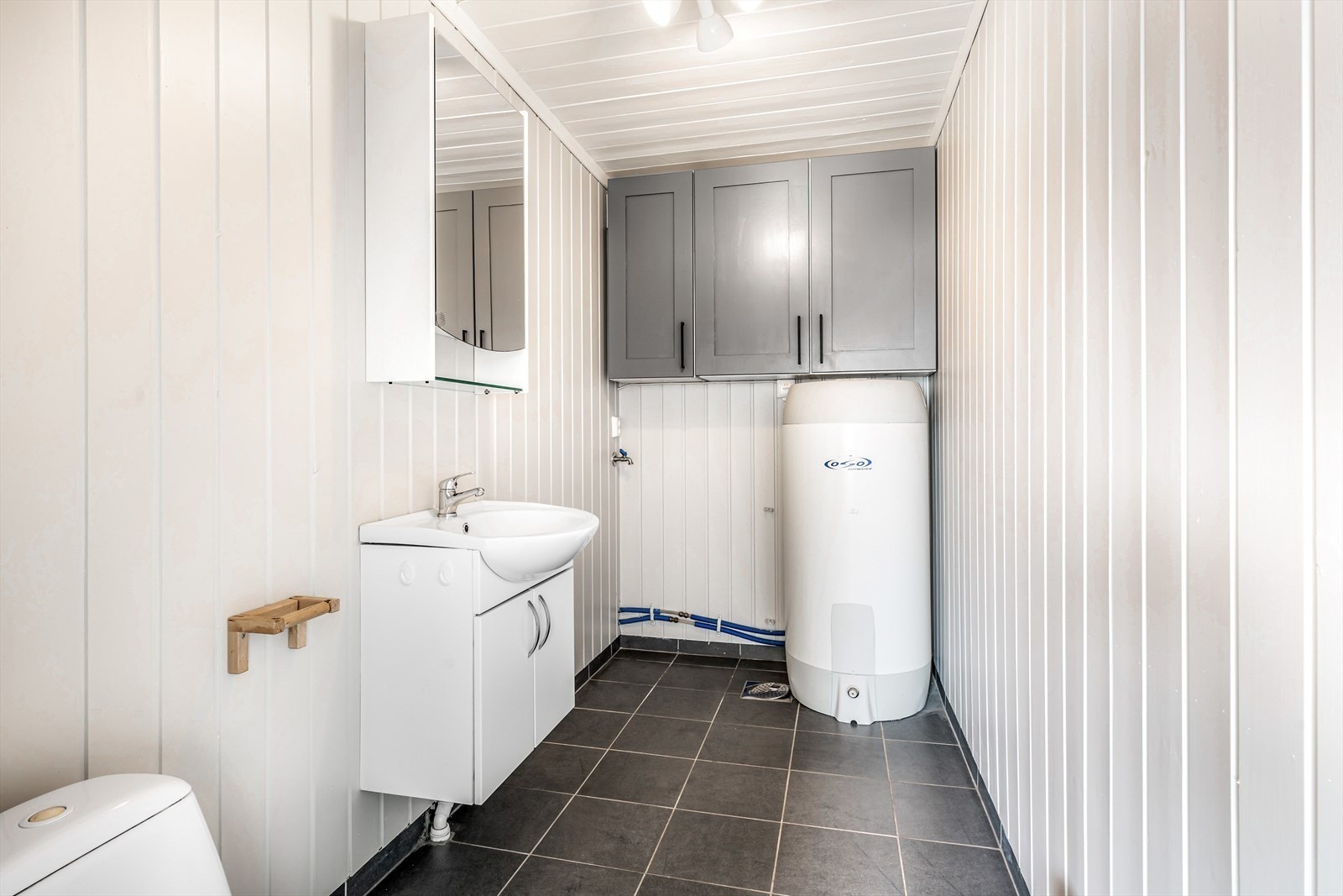 Toalett og vaskerom med opplegg til vaskemaskin. Stor varmtvannsbereder. Galleribilde