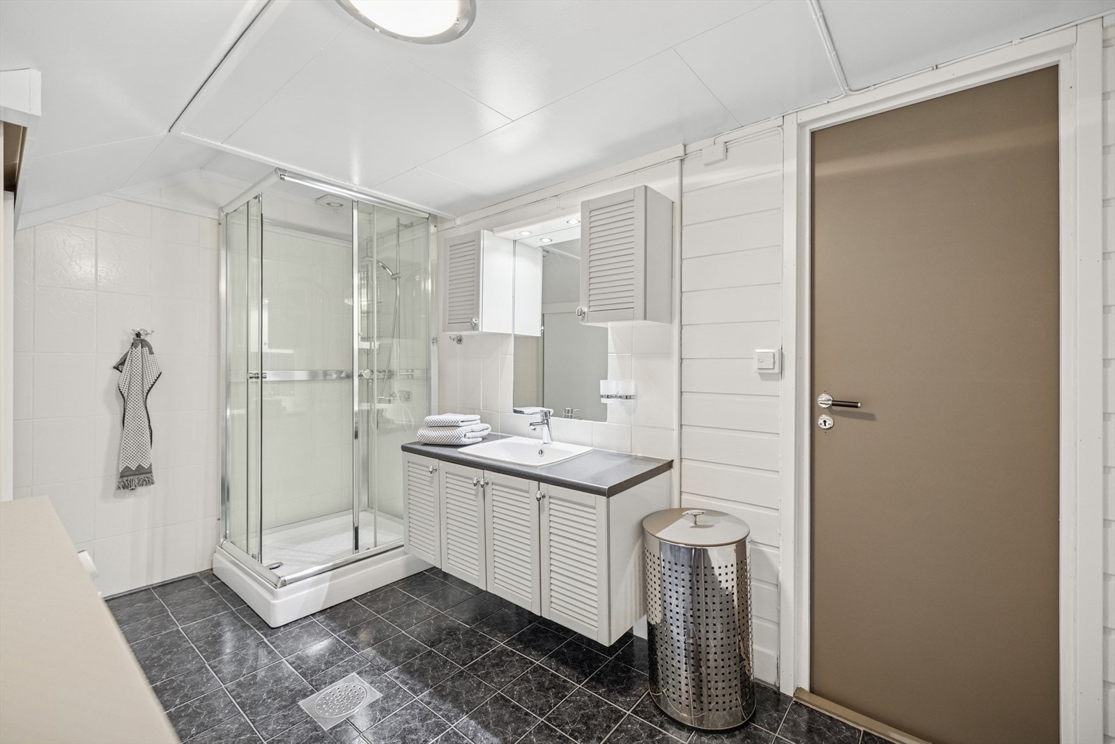 Badet er fint innredet med praktiske skap samt uttak til vaskemaskin Galleribilde