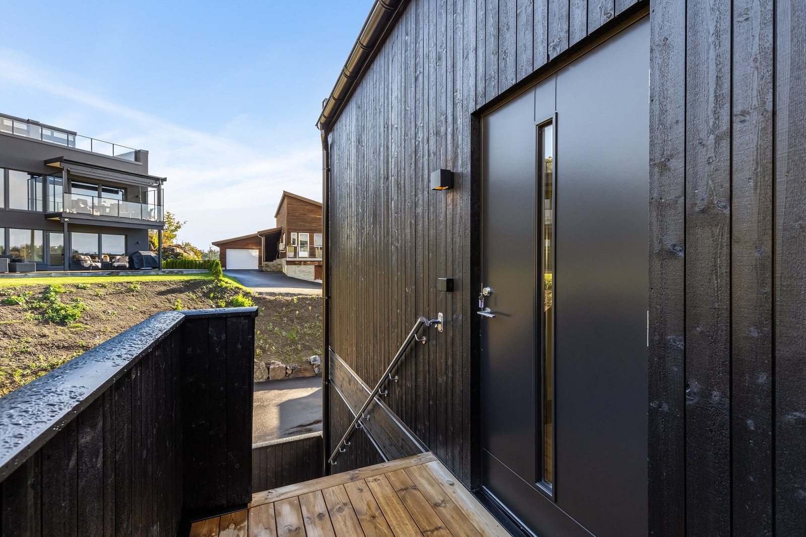 Liten uteplass utenfor inngangspartiet med kveldssol. Galleribilde