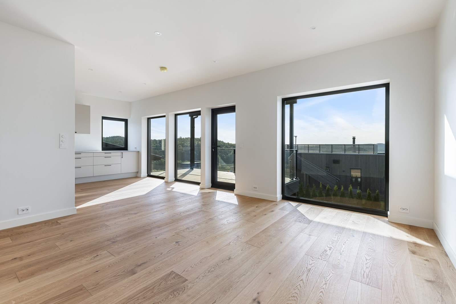 Stue/kjøkken i åpen løsning. Store vindusflater og god takhøyde med downlights i taket. Galleribilde