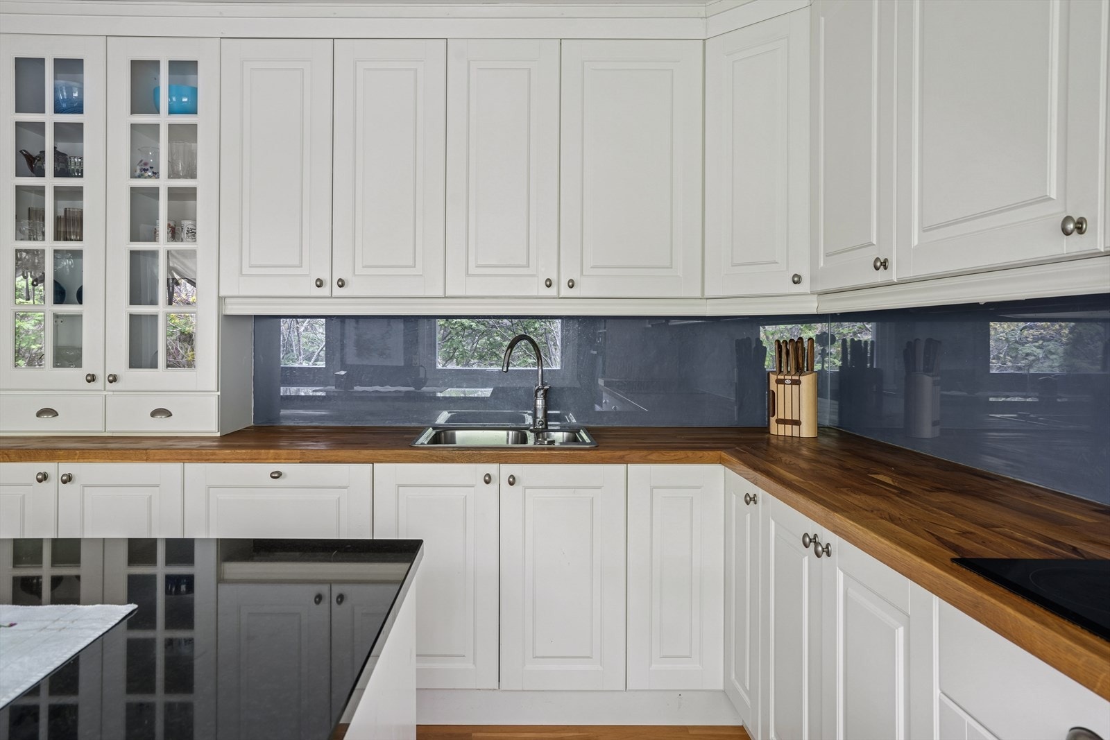 Kjøkkeninnredningen er pent utført med hvite, profilerte fronter og heltre benkeplate med nedfelt kjøkkenkum. Galleribilde