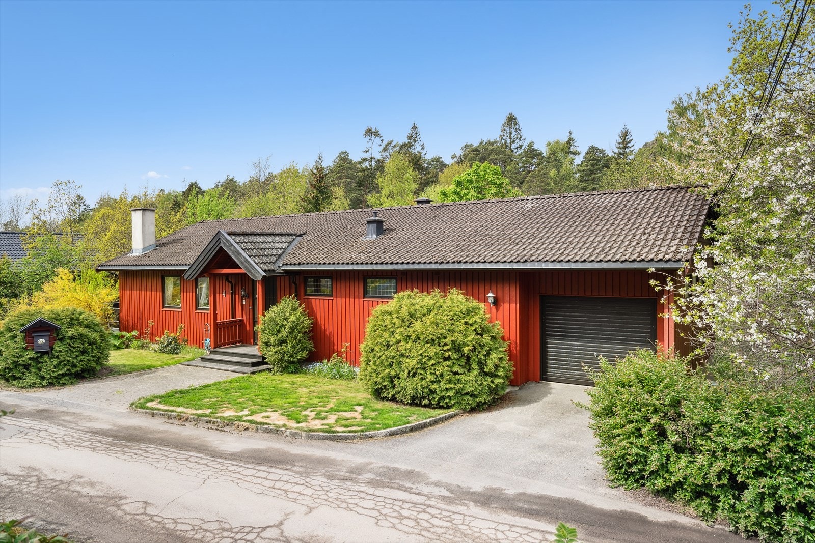 Lettstelt med steinlagt adkomst / inngangsparti og asfalt foran garasje Galleribilde