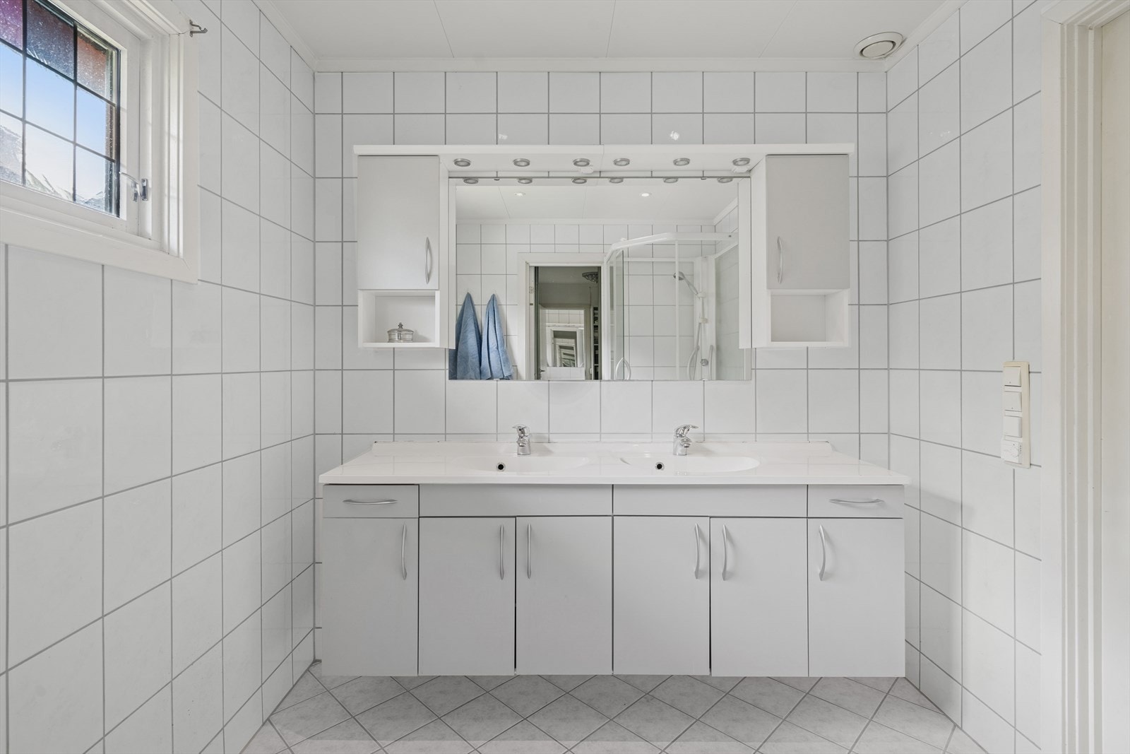 Badet i første etasje har flislagte overflater med behagelige varmekabler i gulvet. Praktisk innredet med dobbel servant. Galleribilde