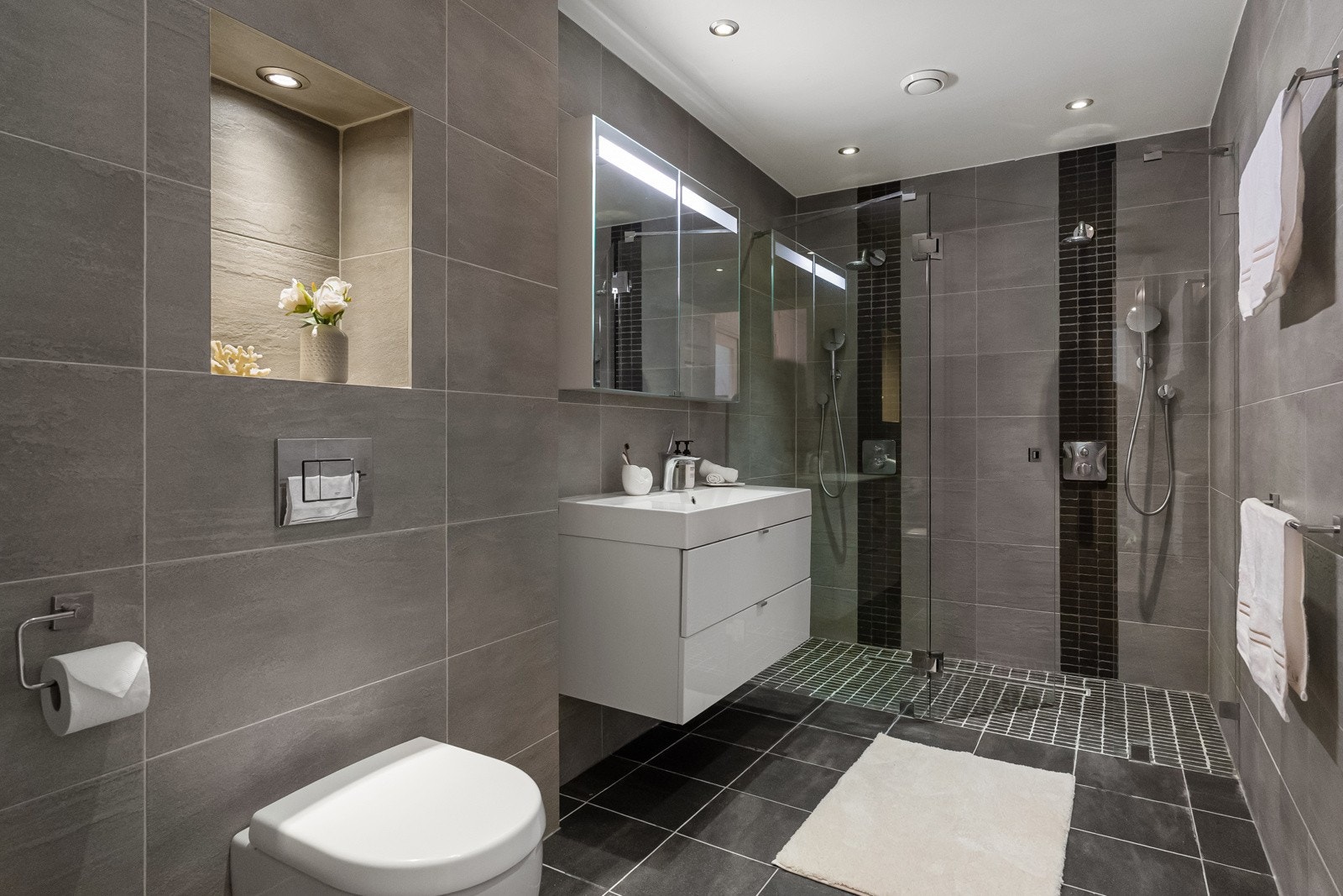 Badet er stilrent og flislagt med varmekabler i gulvet, og ble oppgradert av en tidligere eier i 2011 Galleribilde
