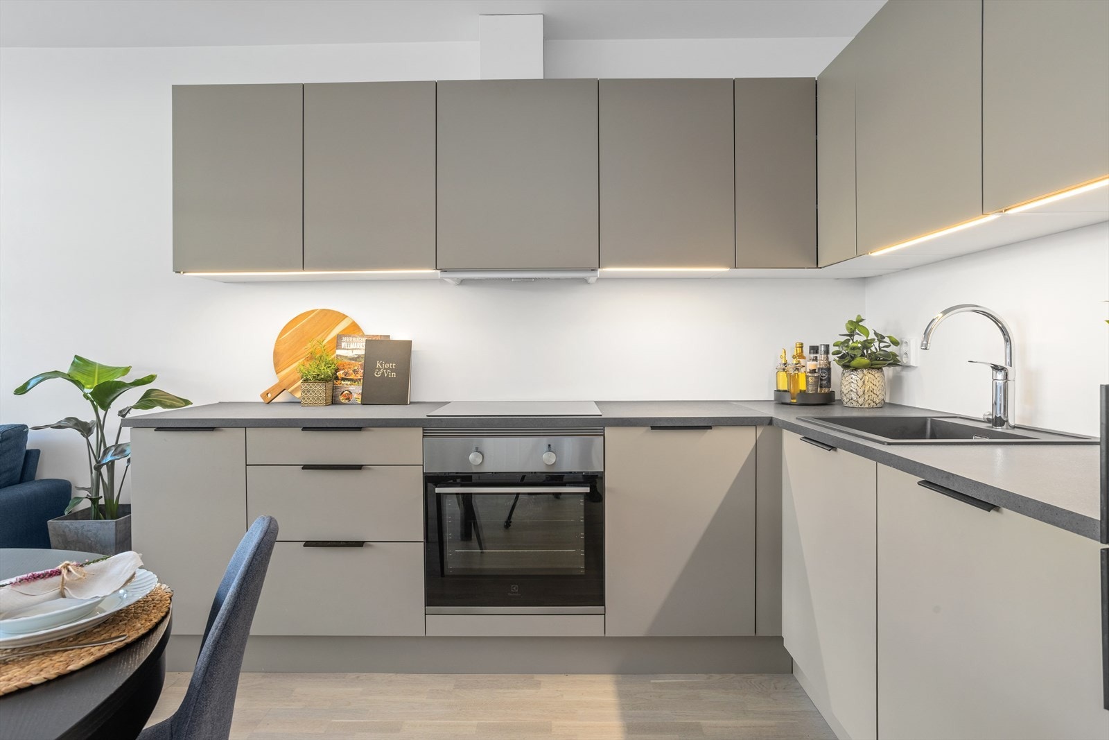 Kjøkkeninnredningen har moderne glatte fronter og benkeplate av laminat. Galleribilde