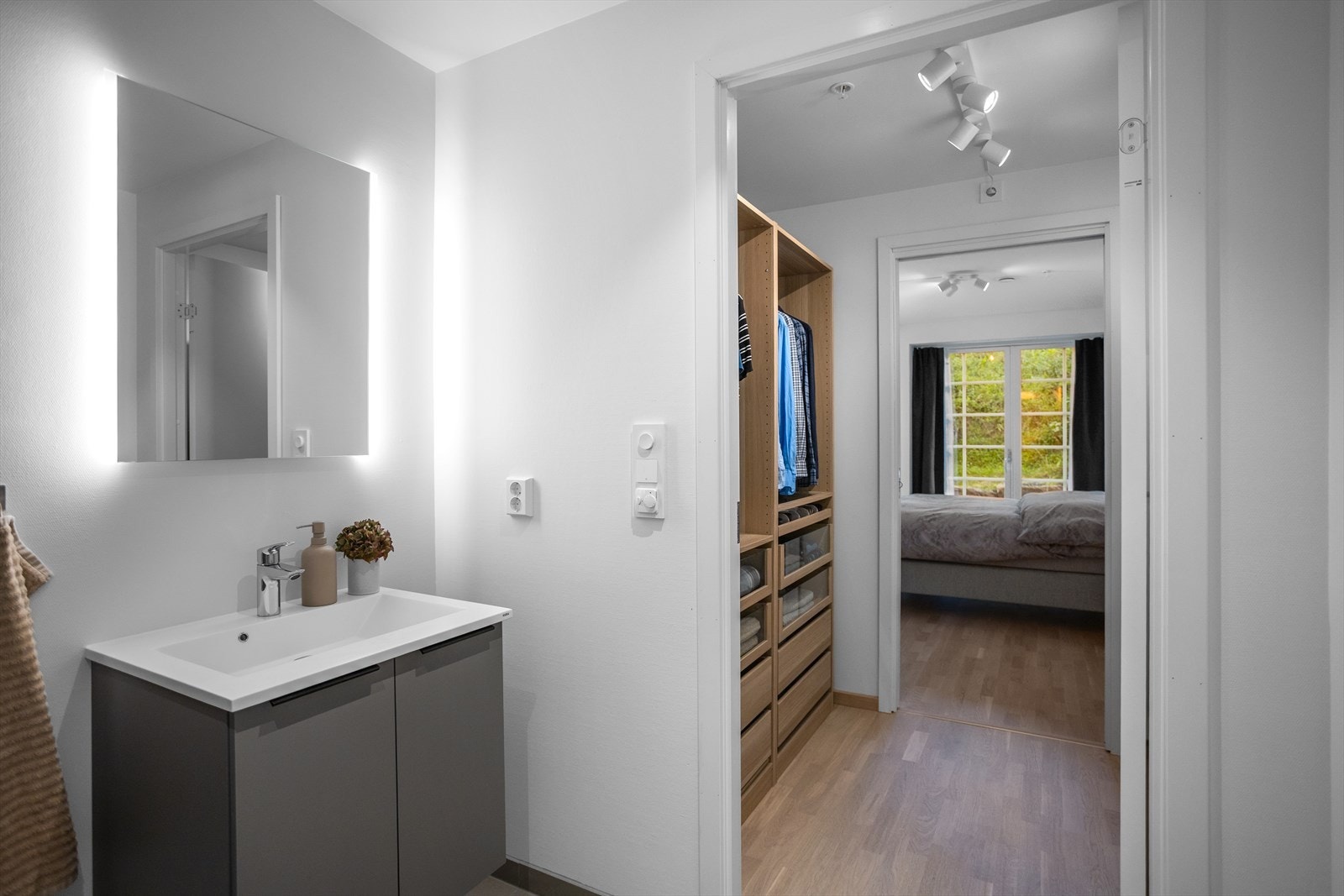 Innredning i grå, delikat utførelse med underskap, nedfelt servant og speil med belysning. Videre har badet vegghengt toalett, dusjhjørne med innfellbare dusjvegger og varmekabler. Galleribilde