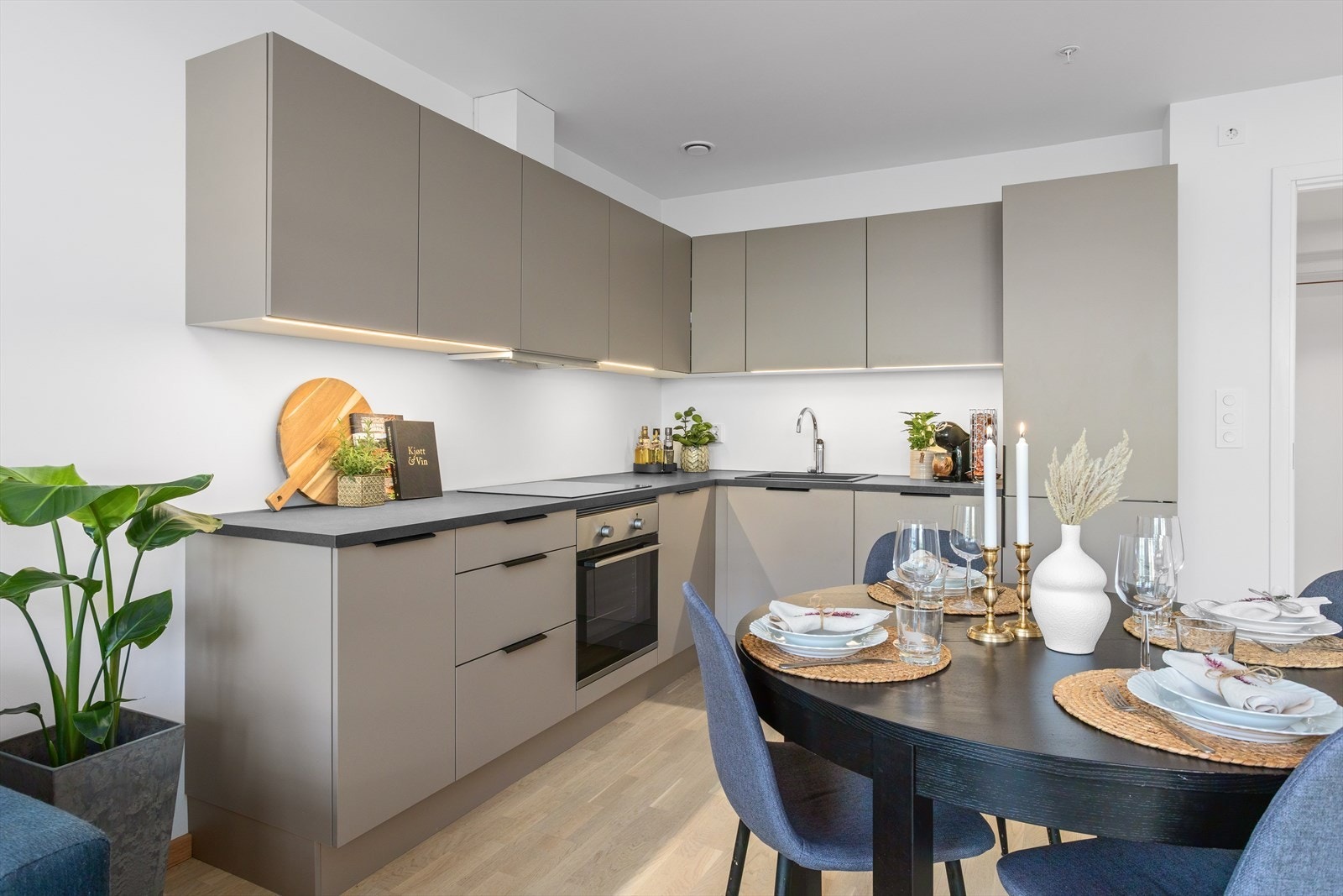 Delikat og stilrent kjøkkeninnredning i hjørne med mye skap og benkeplass. Galleribilde